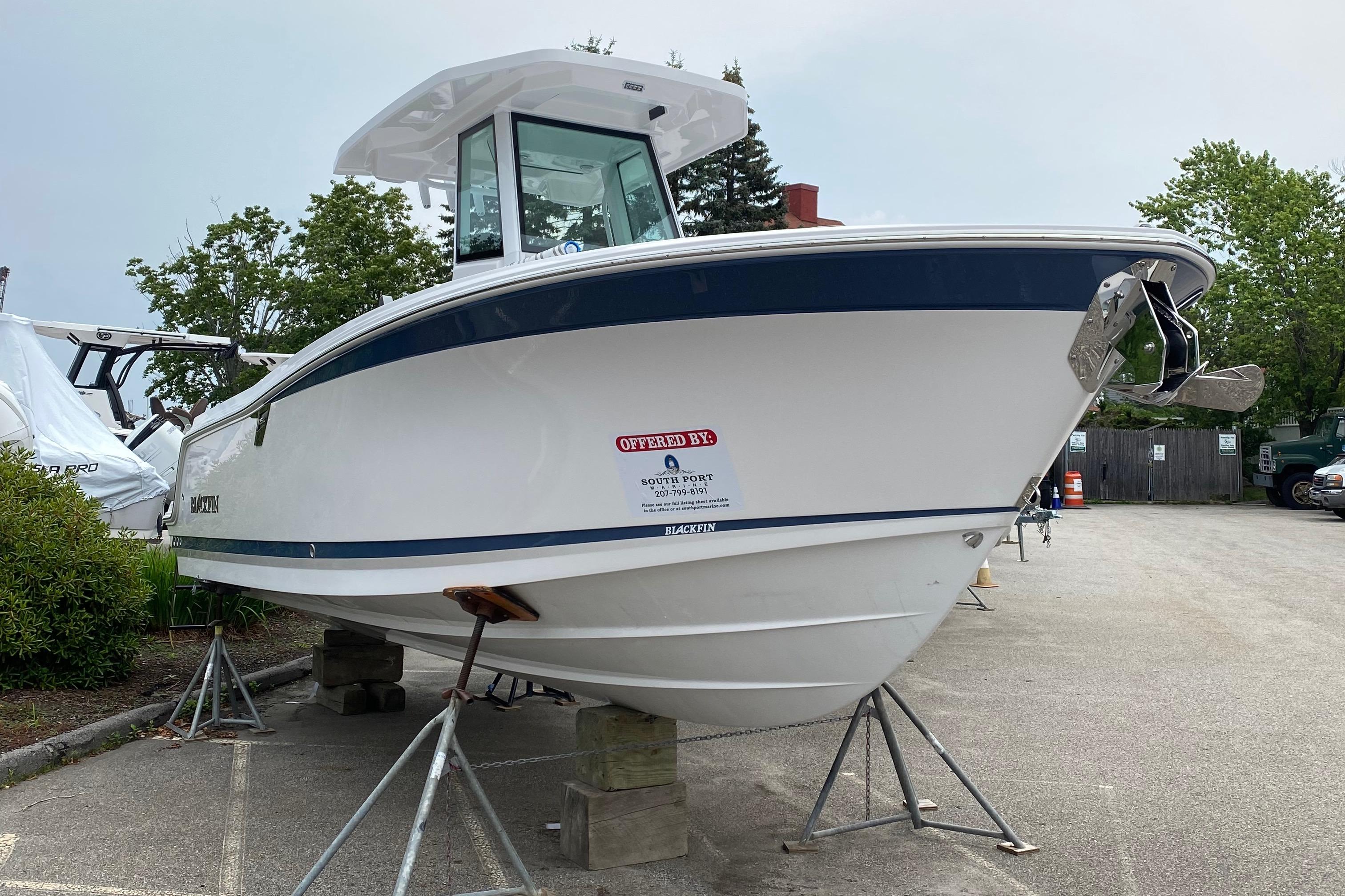 2025 Blackfin 252 CC boat on display, elevated on stands in a parking area.
