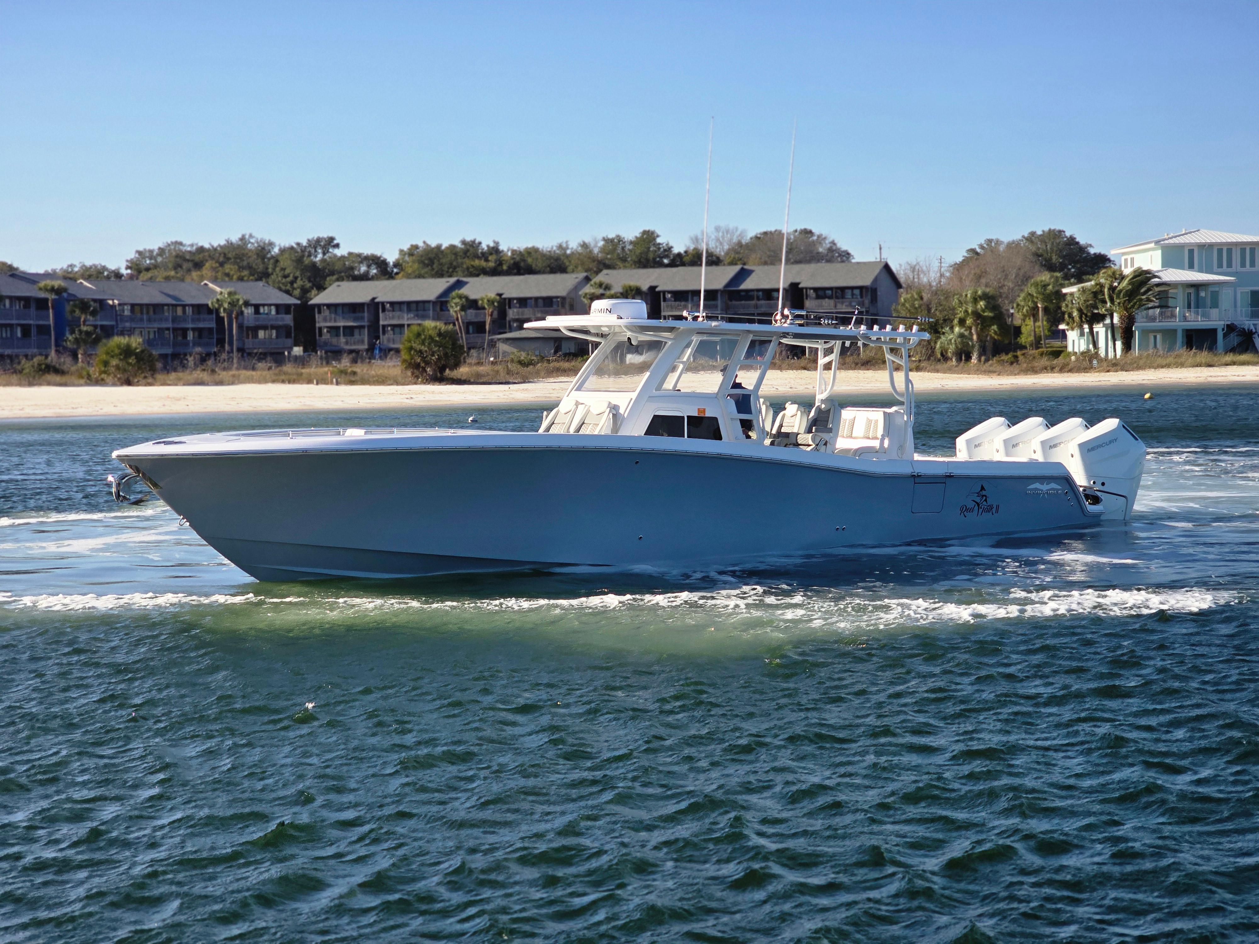 2024 Invincible 43 Open Fisherman boat cruising on water near shoreline.