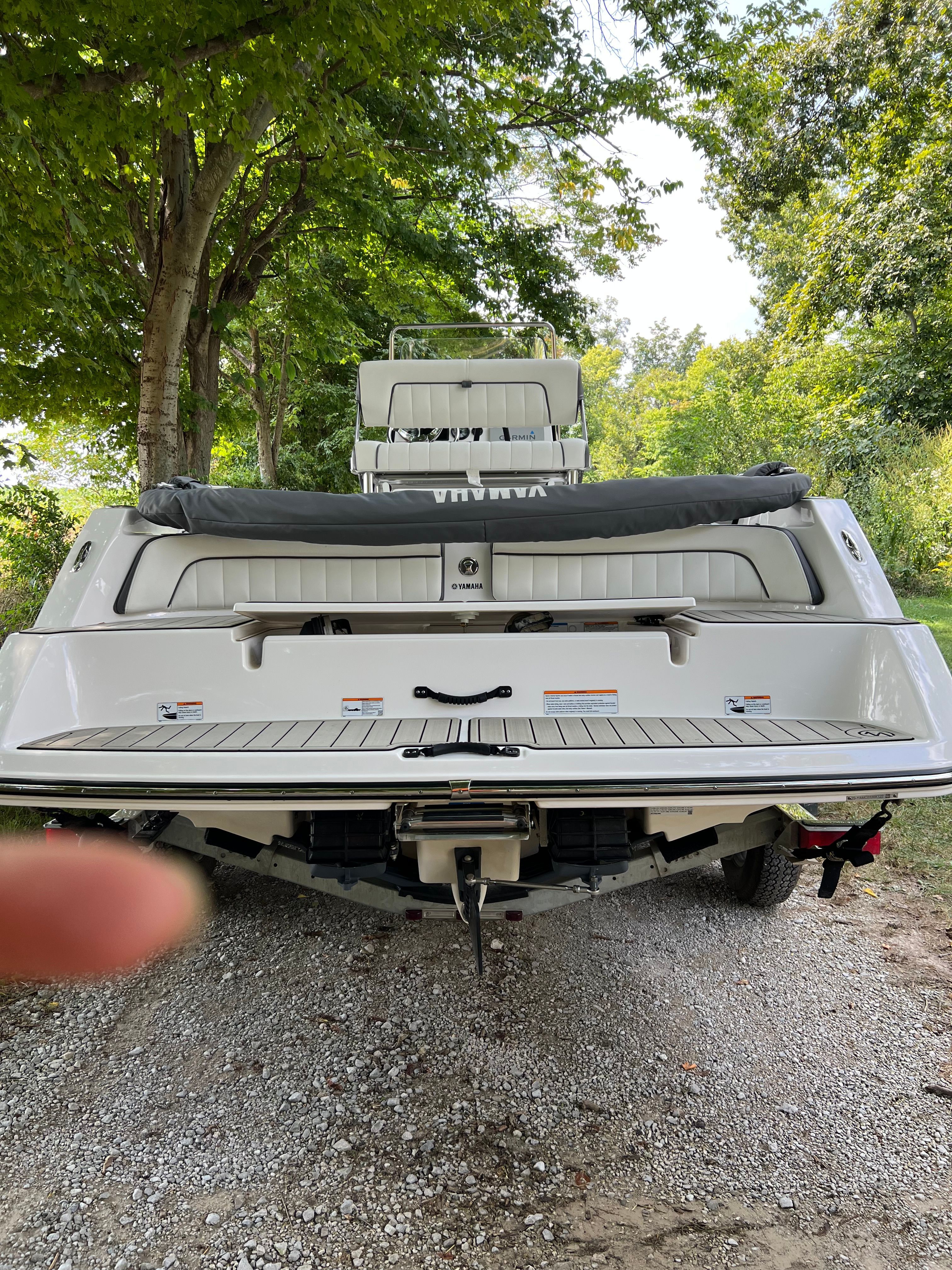 Rear view of 2022 Yamaha Boats 210 FSH Deluxe on gravel path.