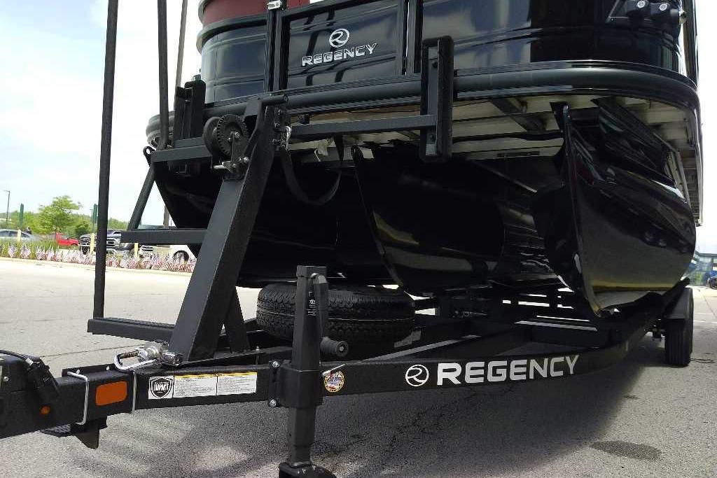 2026 Regency 230 DL boat on trailer, showcasing sleek black design and branding.