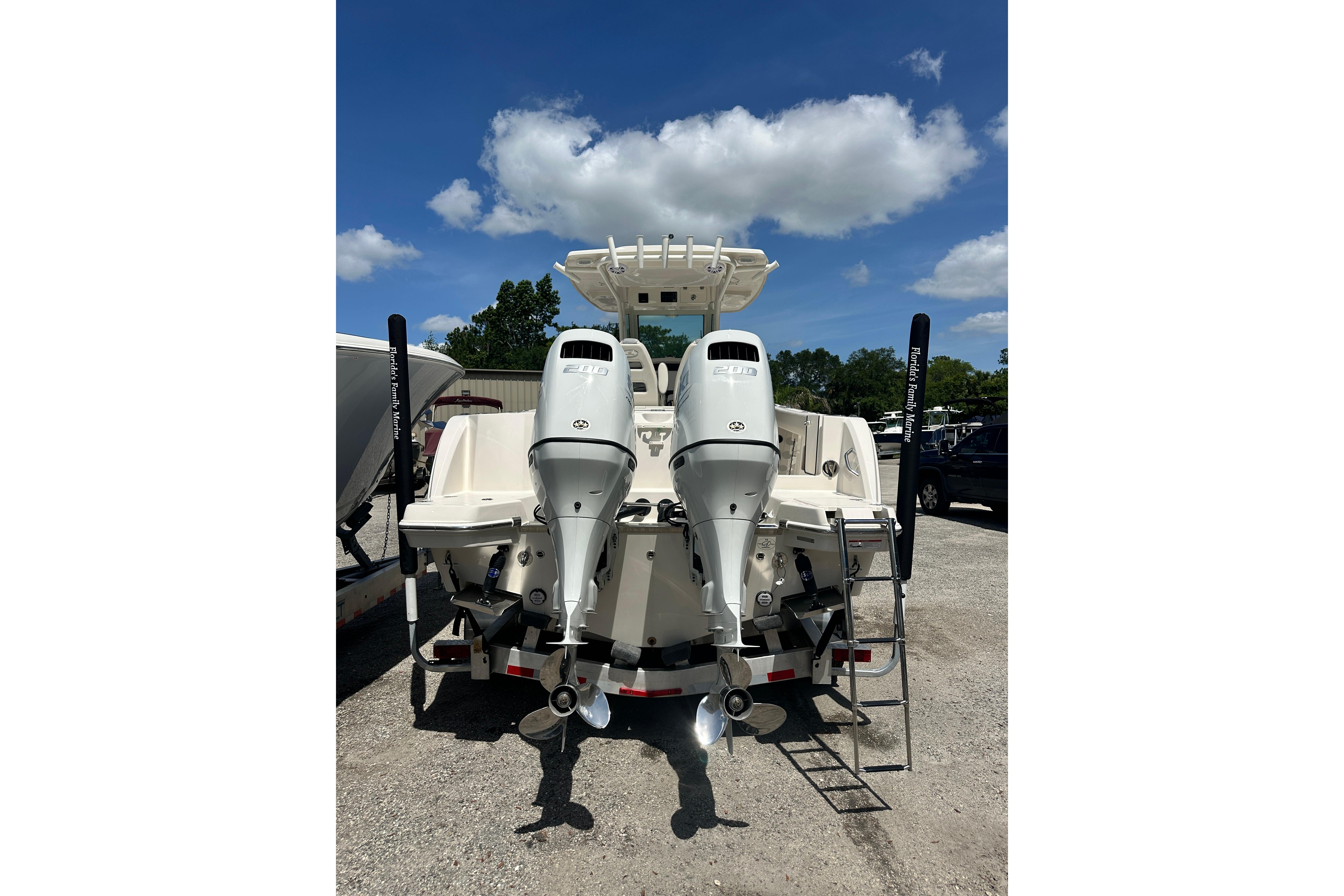 2026 Sailfish 272 CC boat with dual outboard engines, parked outdoors under a blue sky.
