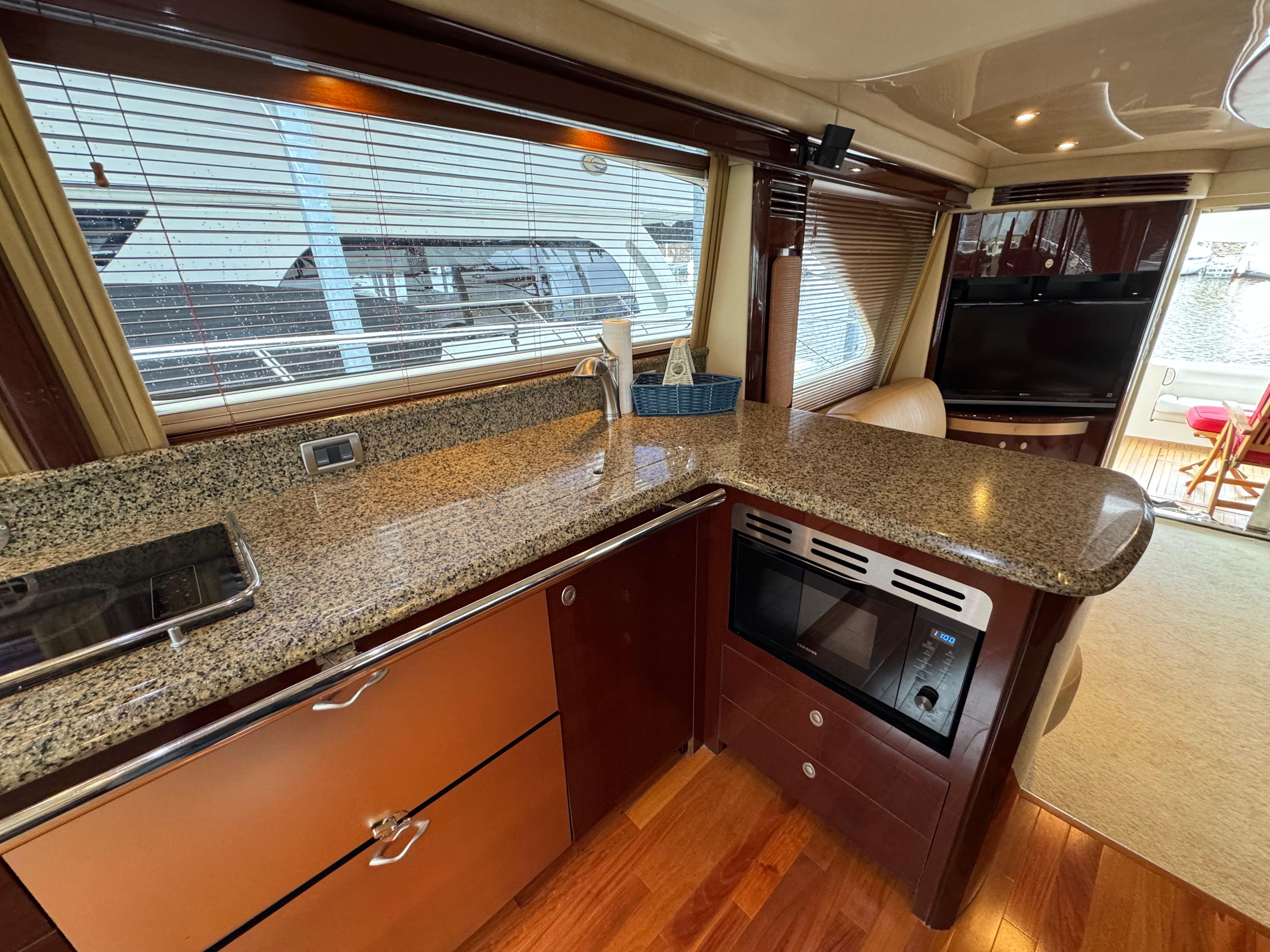 Luxurious kitchen interior of 2007 Sea Ray 58 Sedan Bridge yacht with granite countertops.