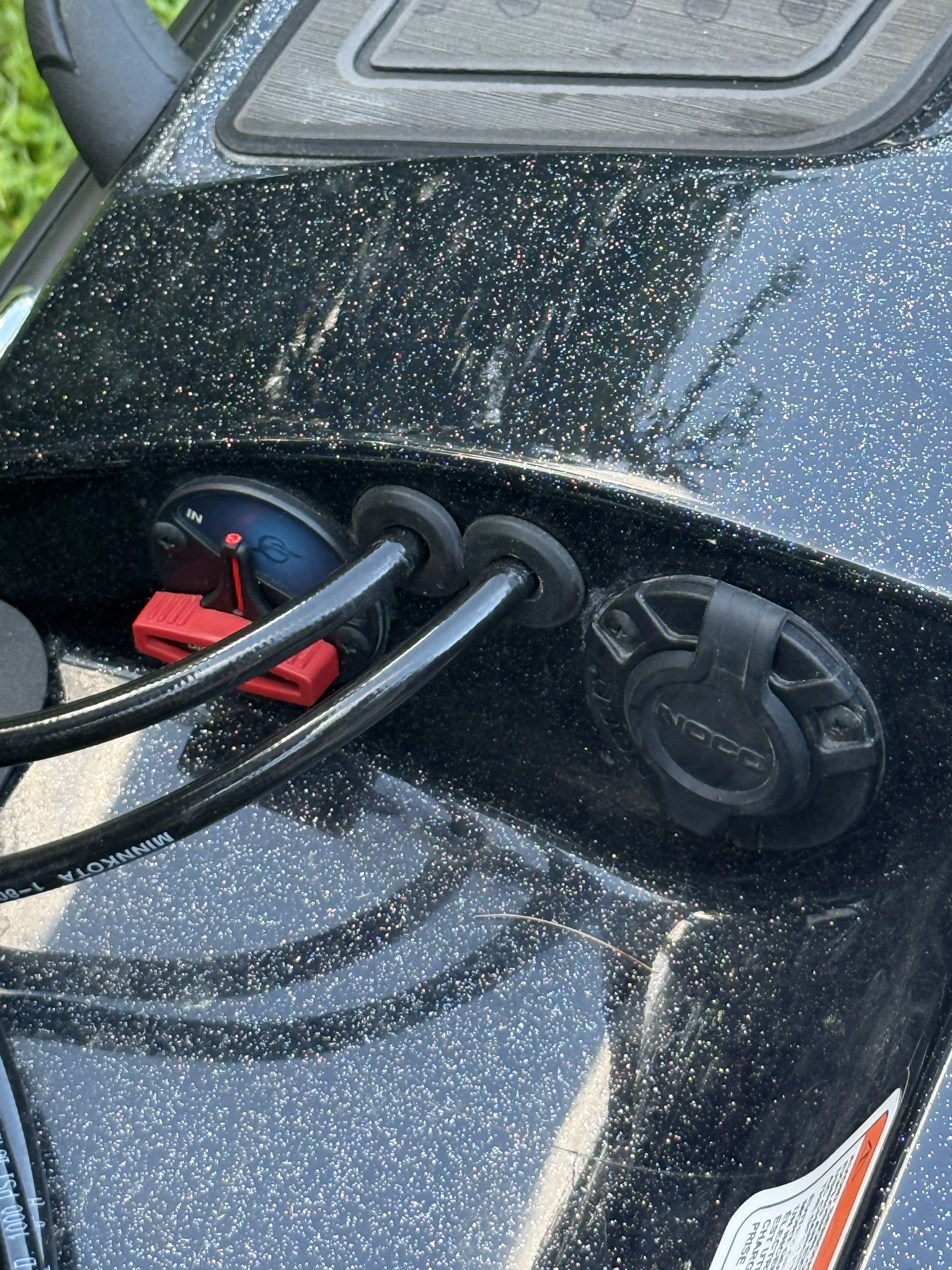 Close-up of a boat dashboard with cable connections and switches.