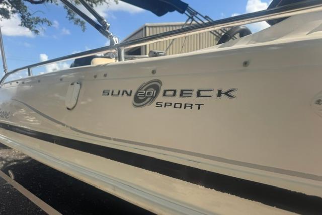 1999 Hurricane SunDeck Sport 201 OB boat, side view with logo, outdoors.
