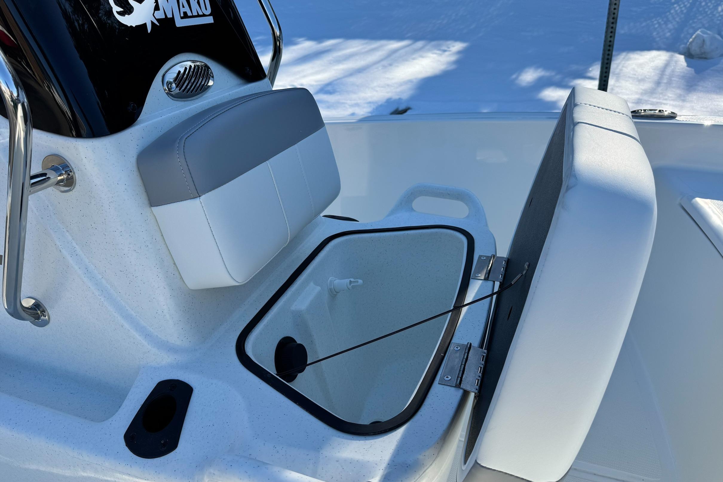 2026 Mako Pro Skiff 15 CC boat interior with storage compartment and cushioned seat.