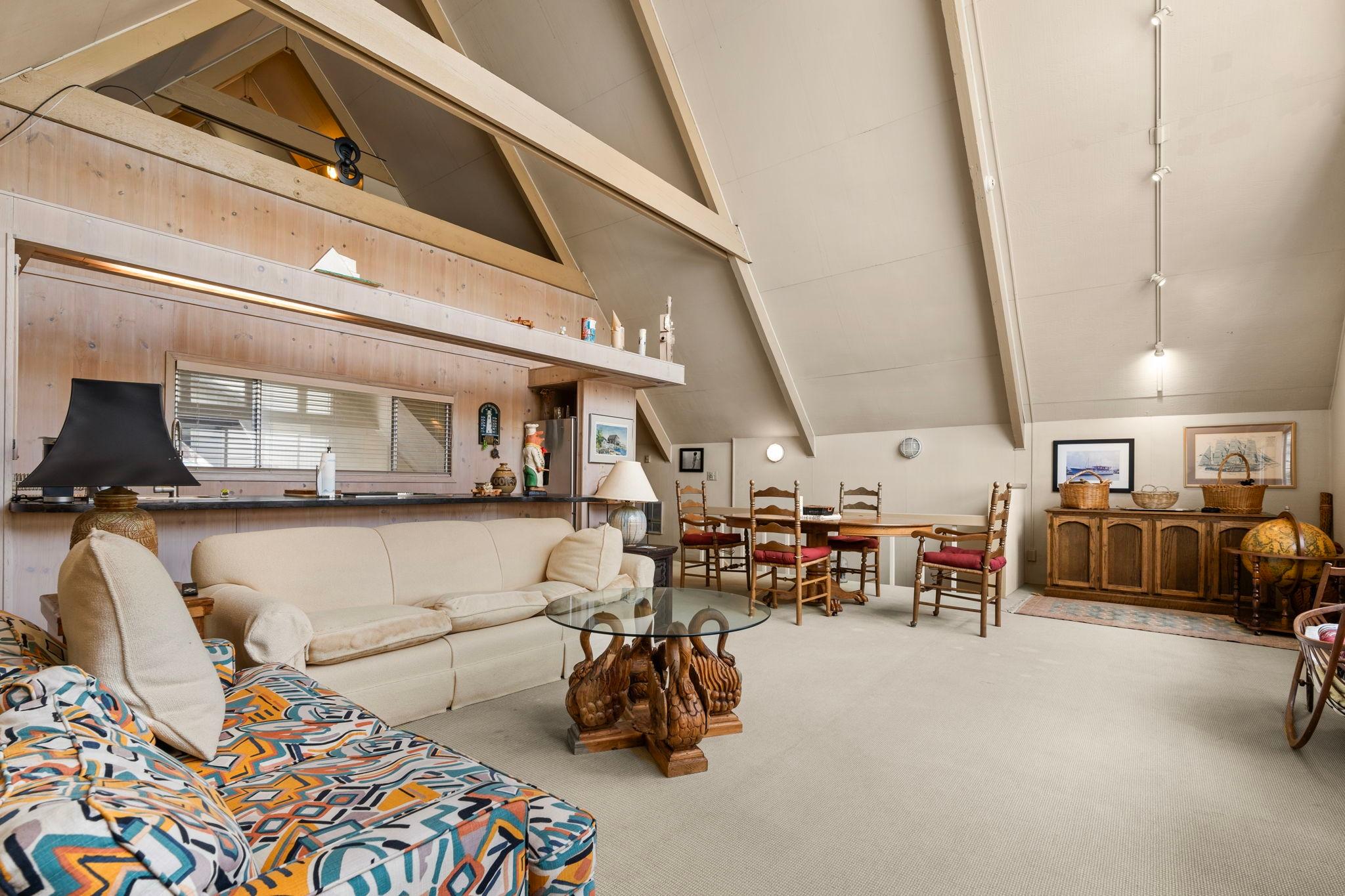 Spacious 1976 custom boathouse interior with cozy seating, dining area, and rustic decor.
