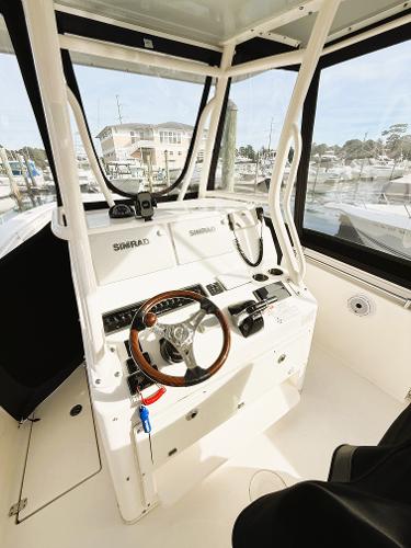 2016 Cobia 296 Center Console boat interior with steering wheel and navigation equipment.