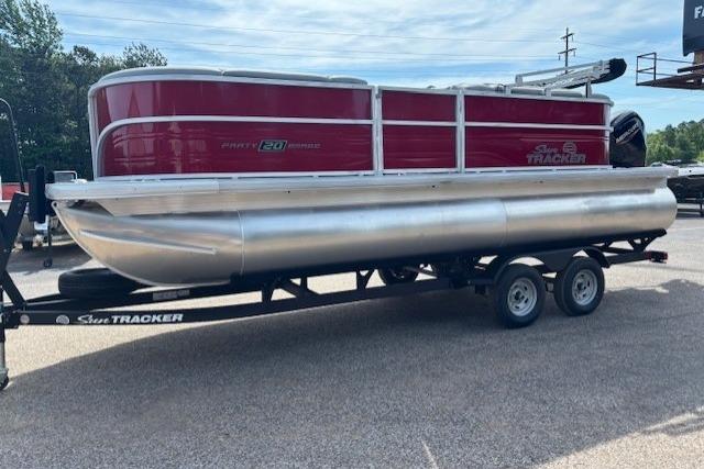 2026 Sun Tracker Party Barge 20 DLX pontoon boat on trailer, red and silver design.