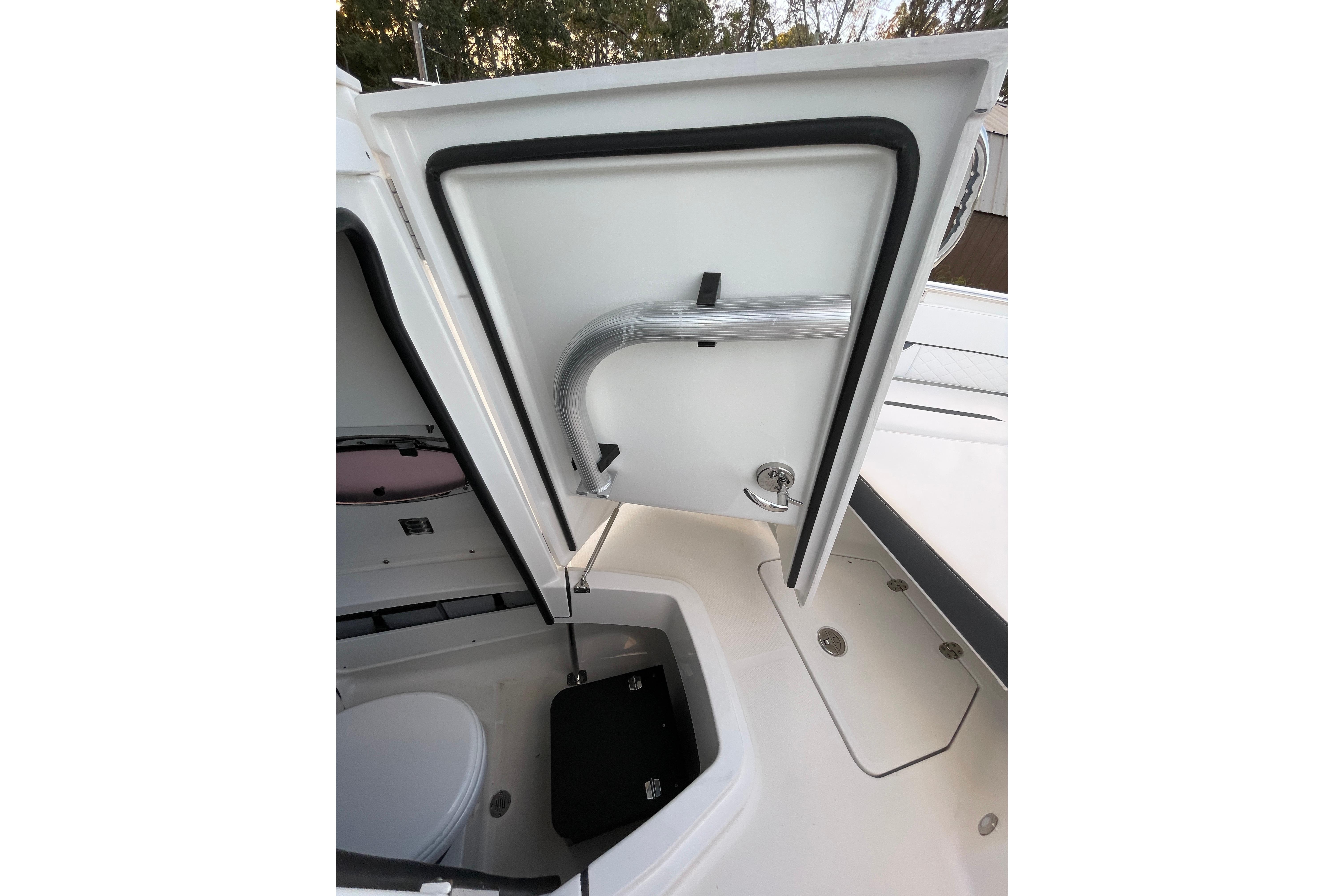 Open storage compartment on 2022 Blackfin 252 CC boat, showcasing interior details.