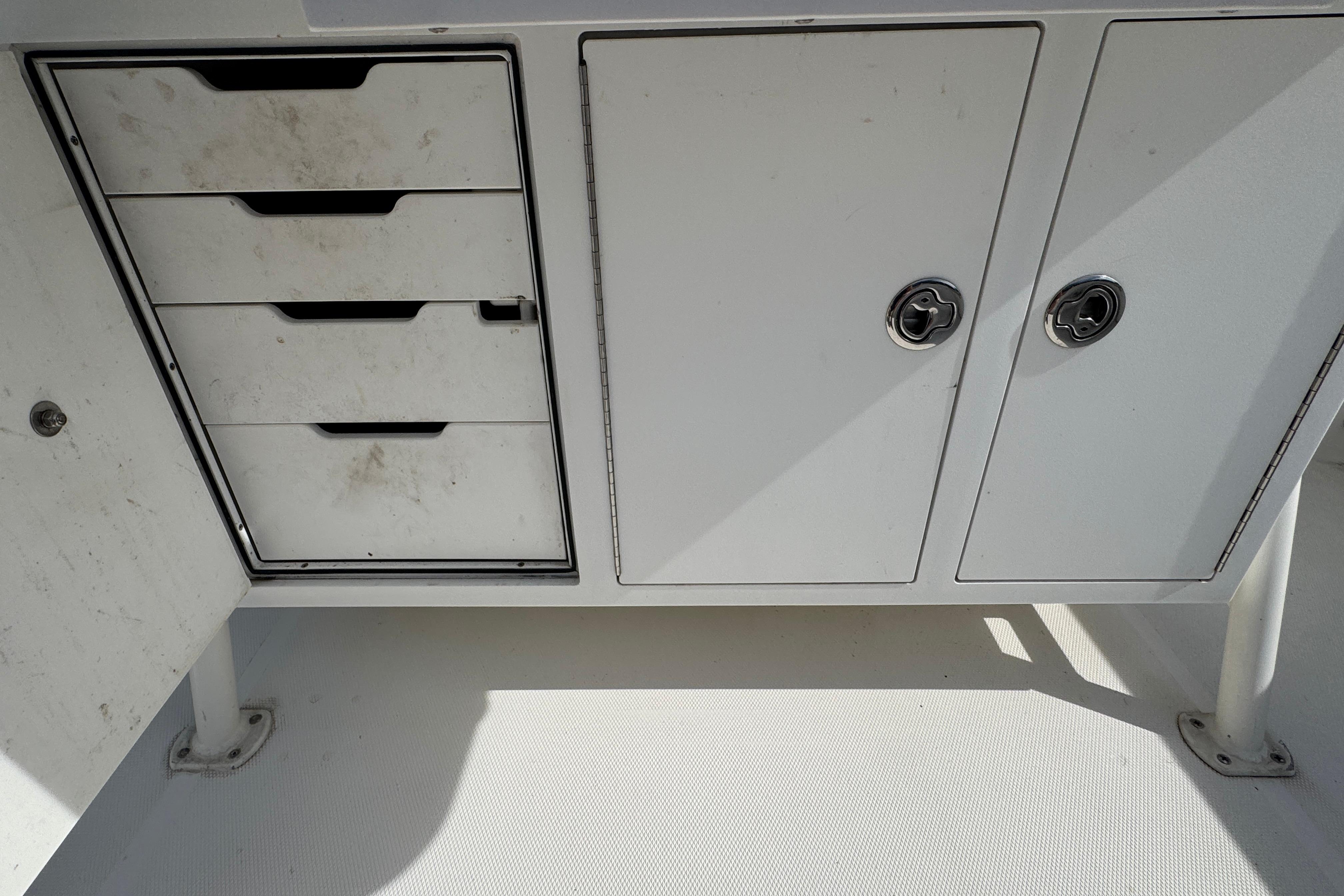 Storage compartments on a 2005 Edgewater 265CC boat, featuring drawers and cabinets.