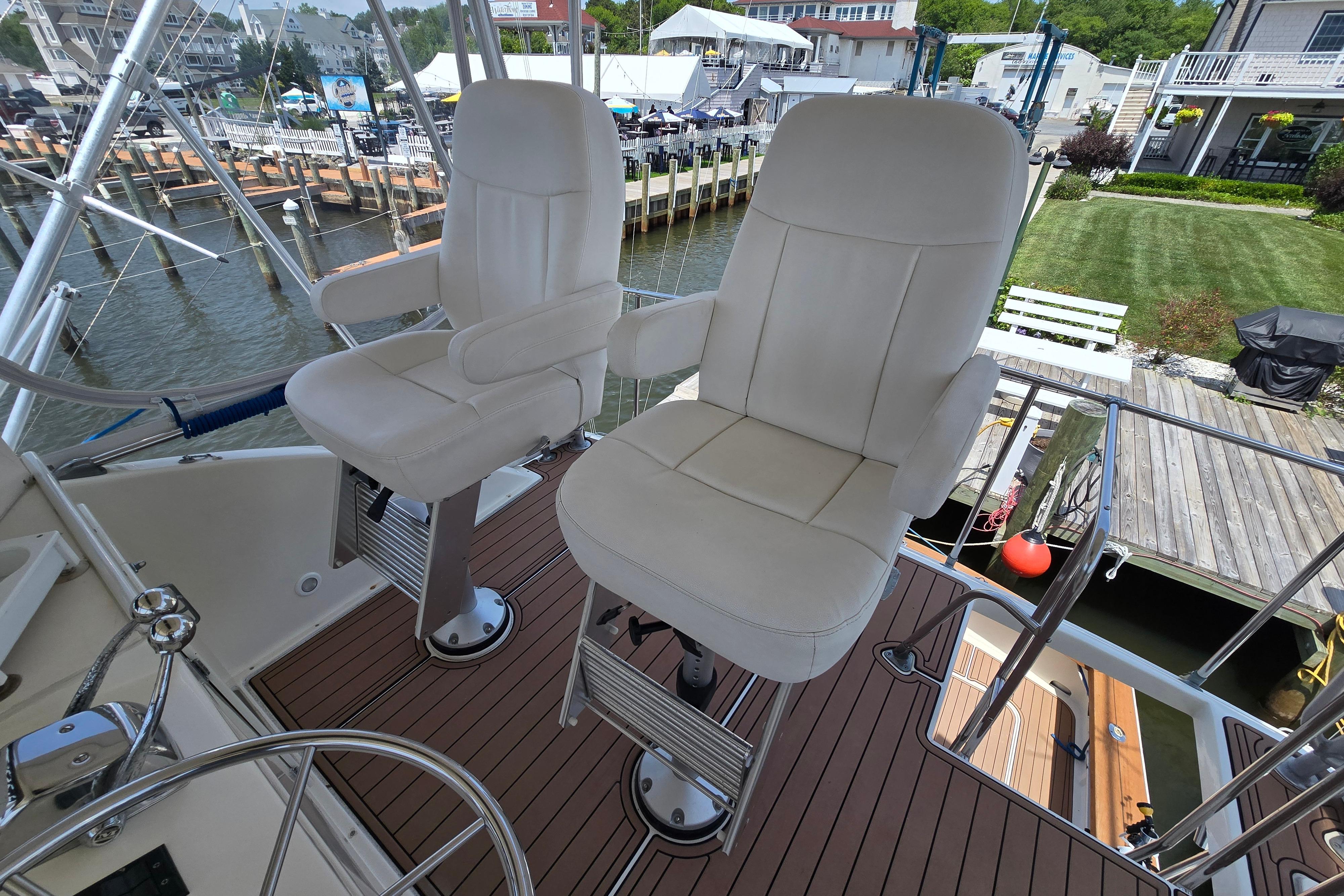 Captain's chairs on 1988 Post 46 Convertible yacht, docked at marina.
