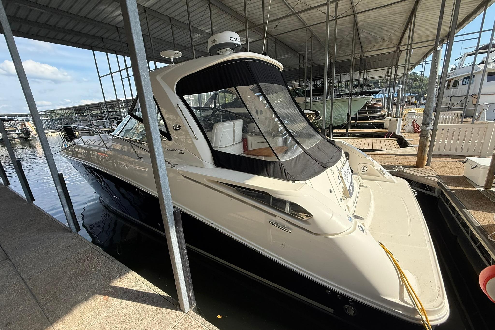 2009 Sea Ray 350 Sundancer docked in a covered marina, side view.