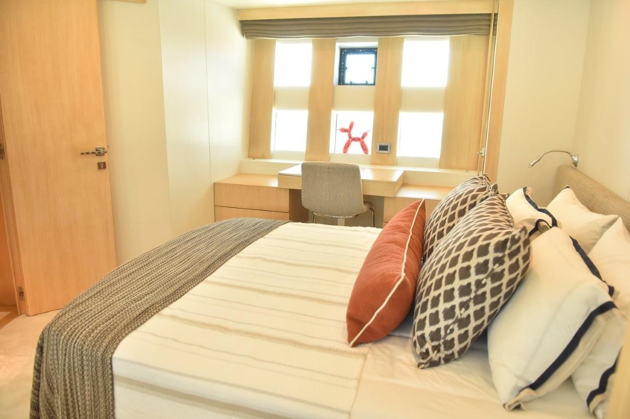 Luxurious bedroom interior on 2007 Azimut 86S yacht with stylish decor and natural light.