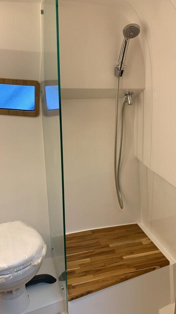 Modern bathroom in 2021 NX Boats 340 Sport Coupe with shower and wooden flooring.