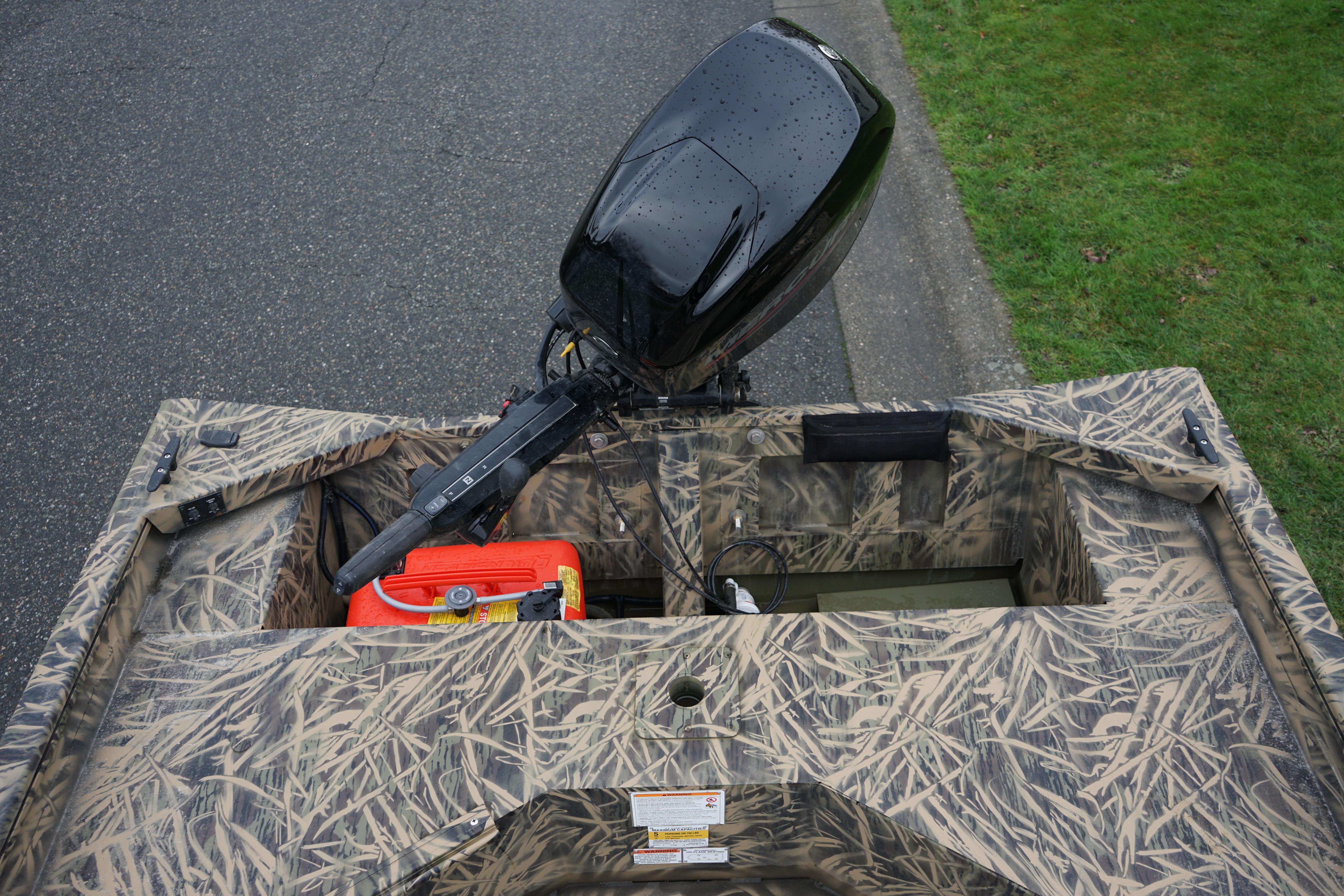 2024 Lund 1760 Predator Tiller boat with camouflage design and outboard motor.