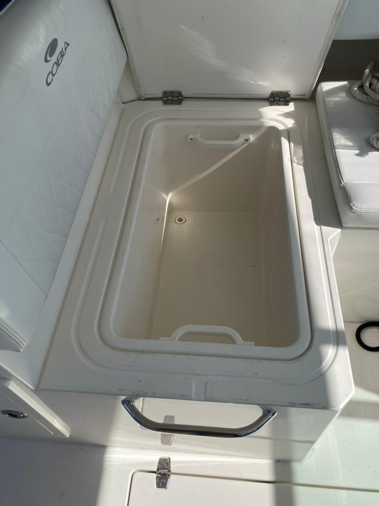 Open storage compartment on a 2023 Cobia 330 boat.