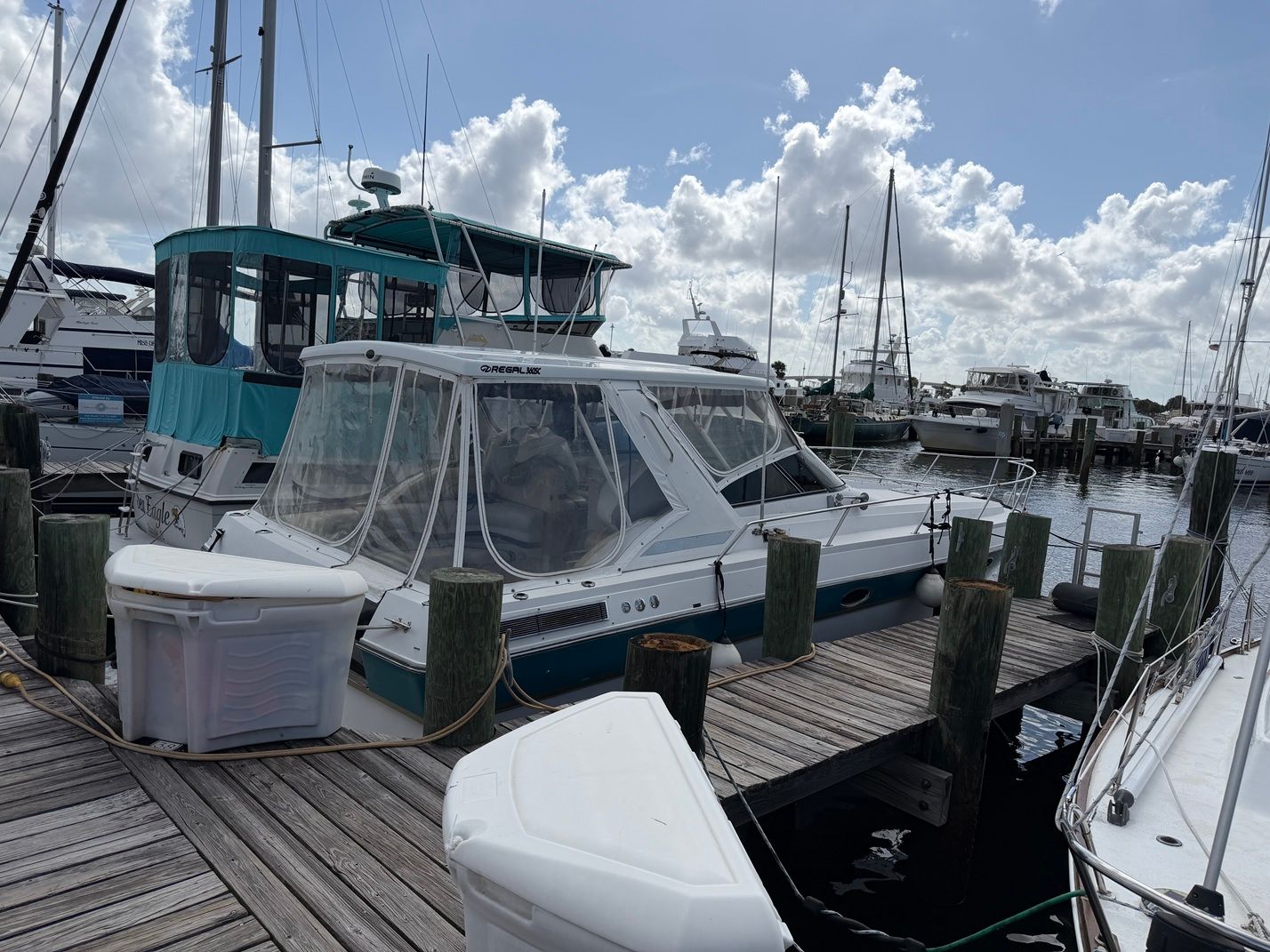 1988 Regal Commodore 360 boat docked at marina under cloudy sky.