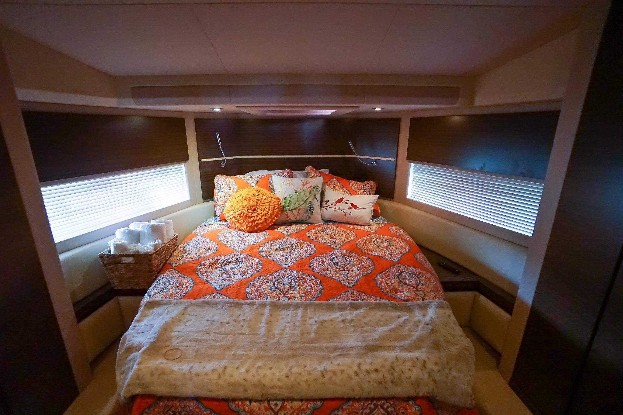 Luxurious bedroom interior of 2014 Azimut 54 Flybridge yacht with vibrant bedding.