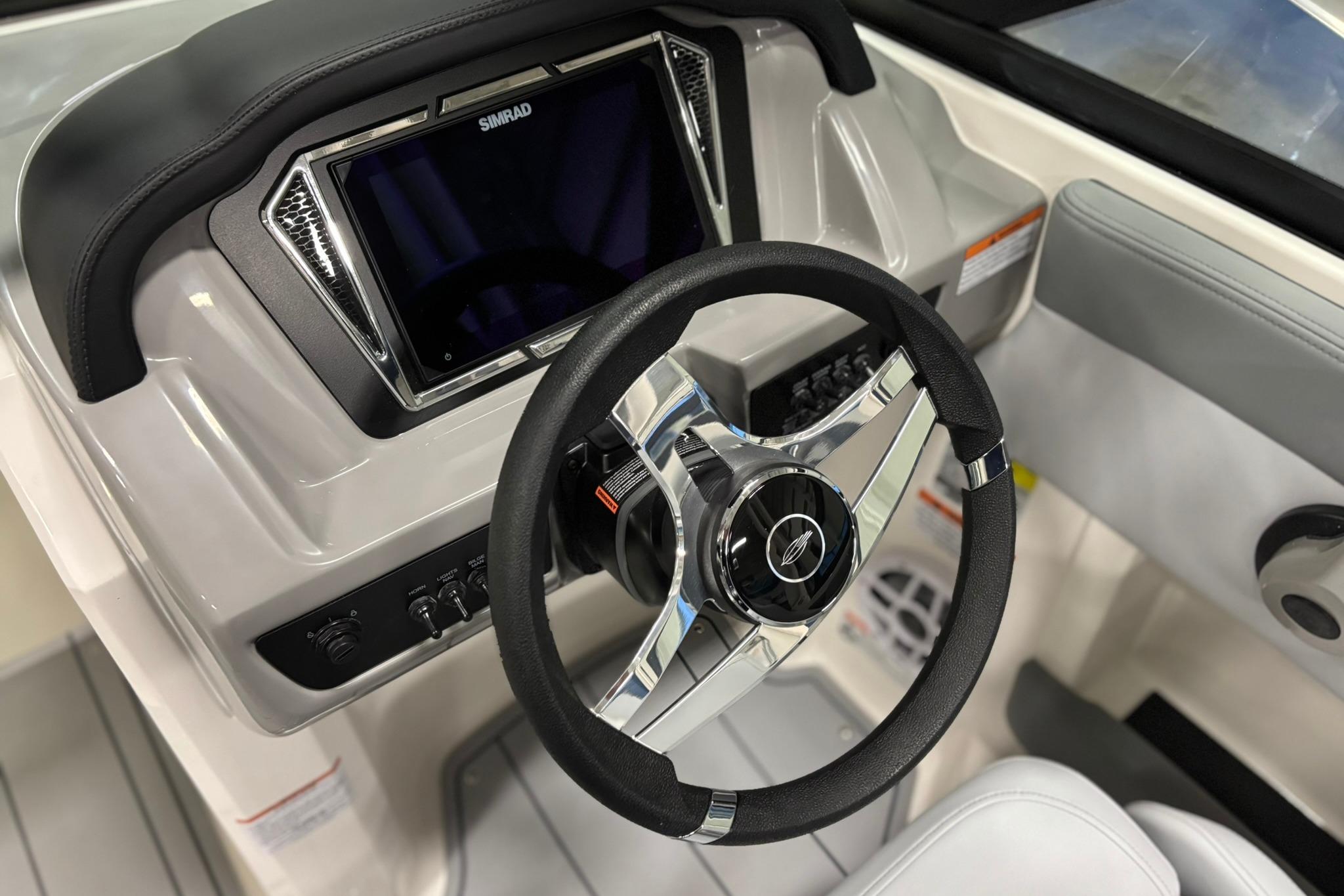 2026 Chaparral 21 SSi OB boat dashboard with steering wheel and Simrad display.