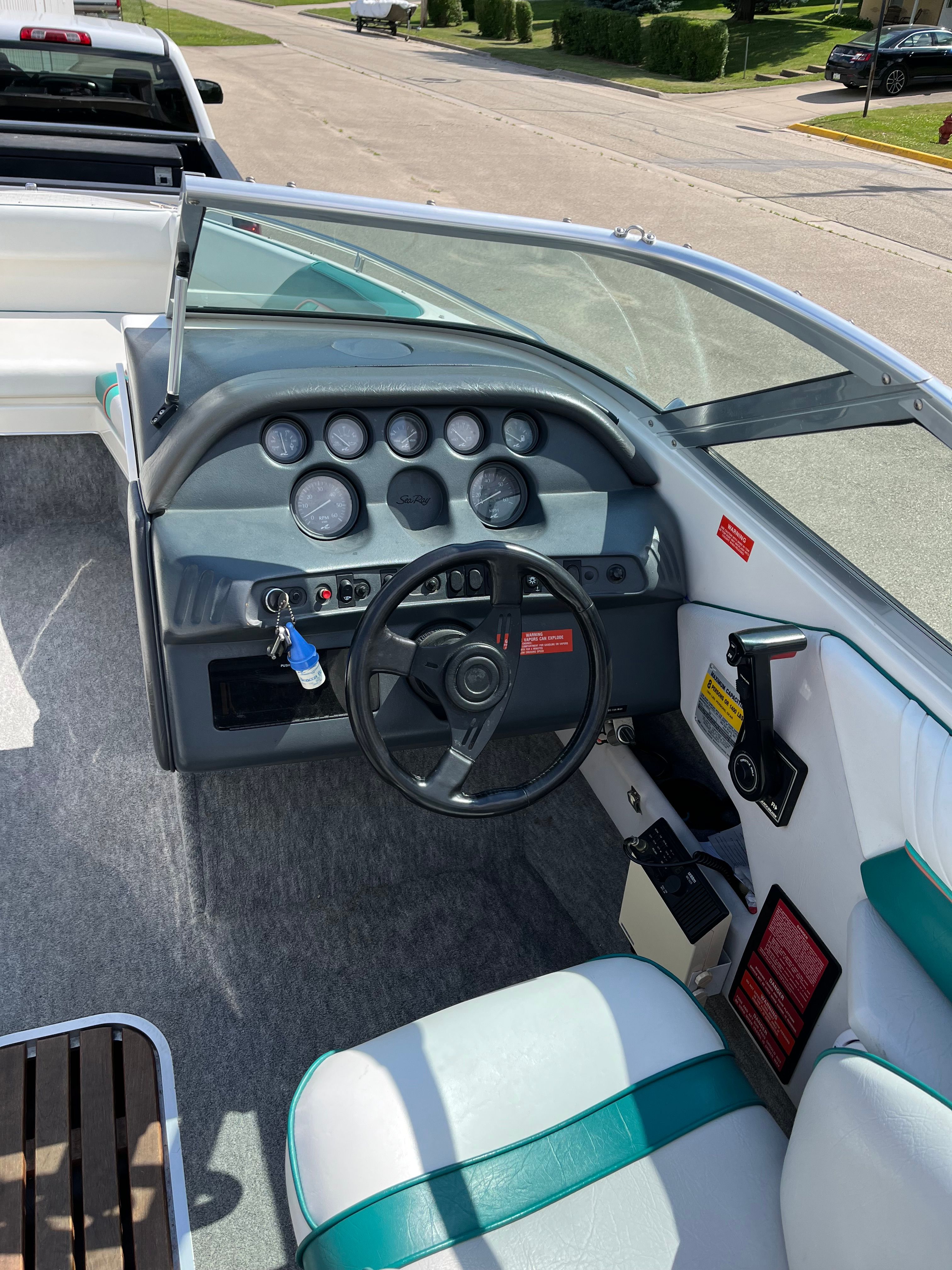 Interior view of a Sea Ray 220 Bow Rider boat with steering wheel and dashboard.