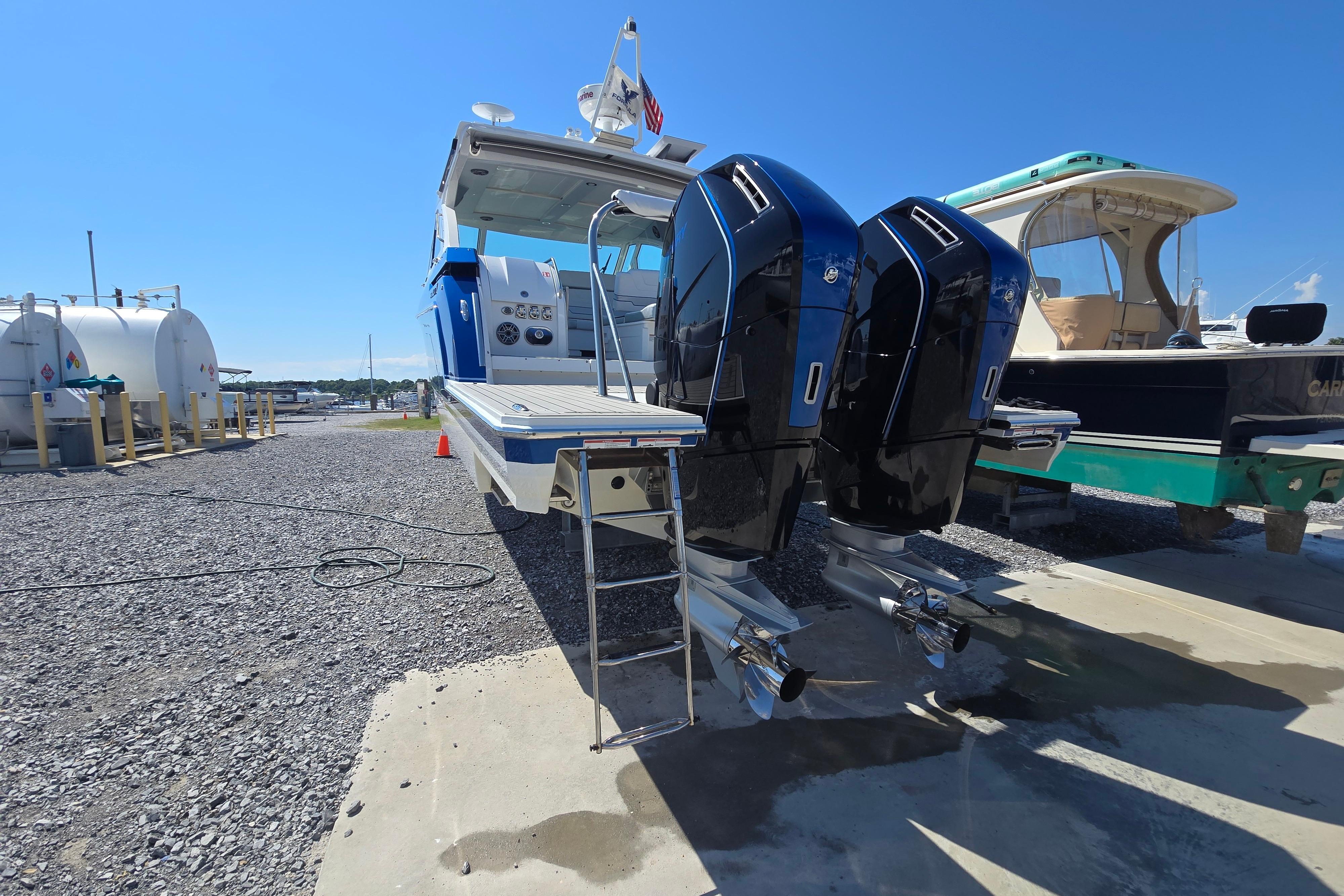 2025 Formula 380 Super Sport Crossover OB with dual outboard engines at a marina.