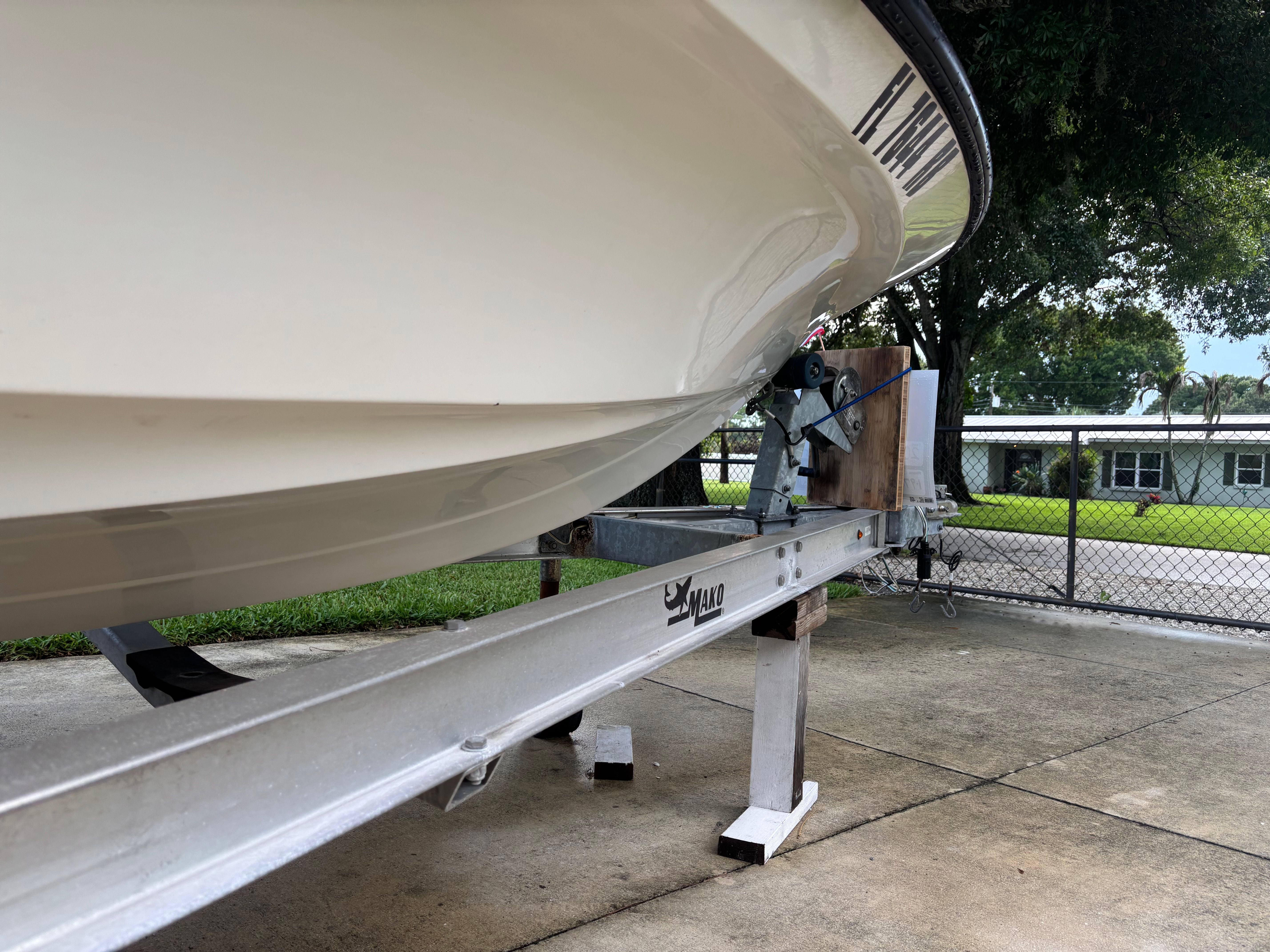 A 2016 Mako 18 LTS boat on a trailer, parked on a concrete surface.