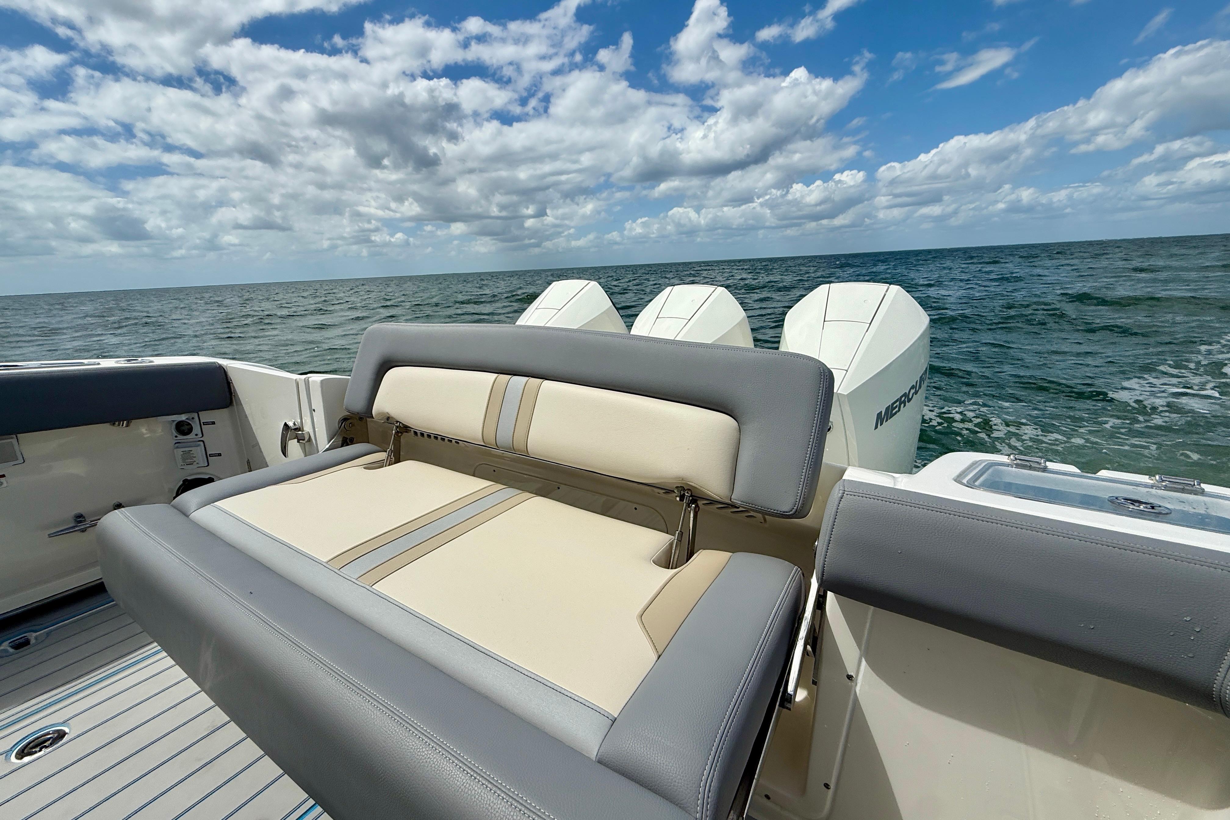 2025 Boston Whaler 350 Realm boat with cushioned seating, ocean view, and outboard motors.