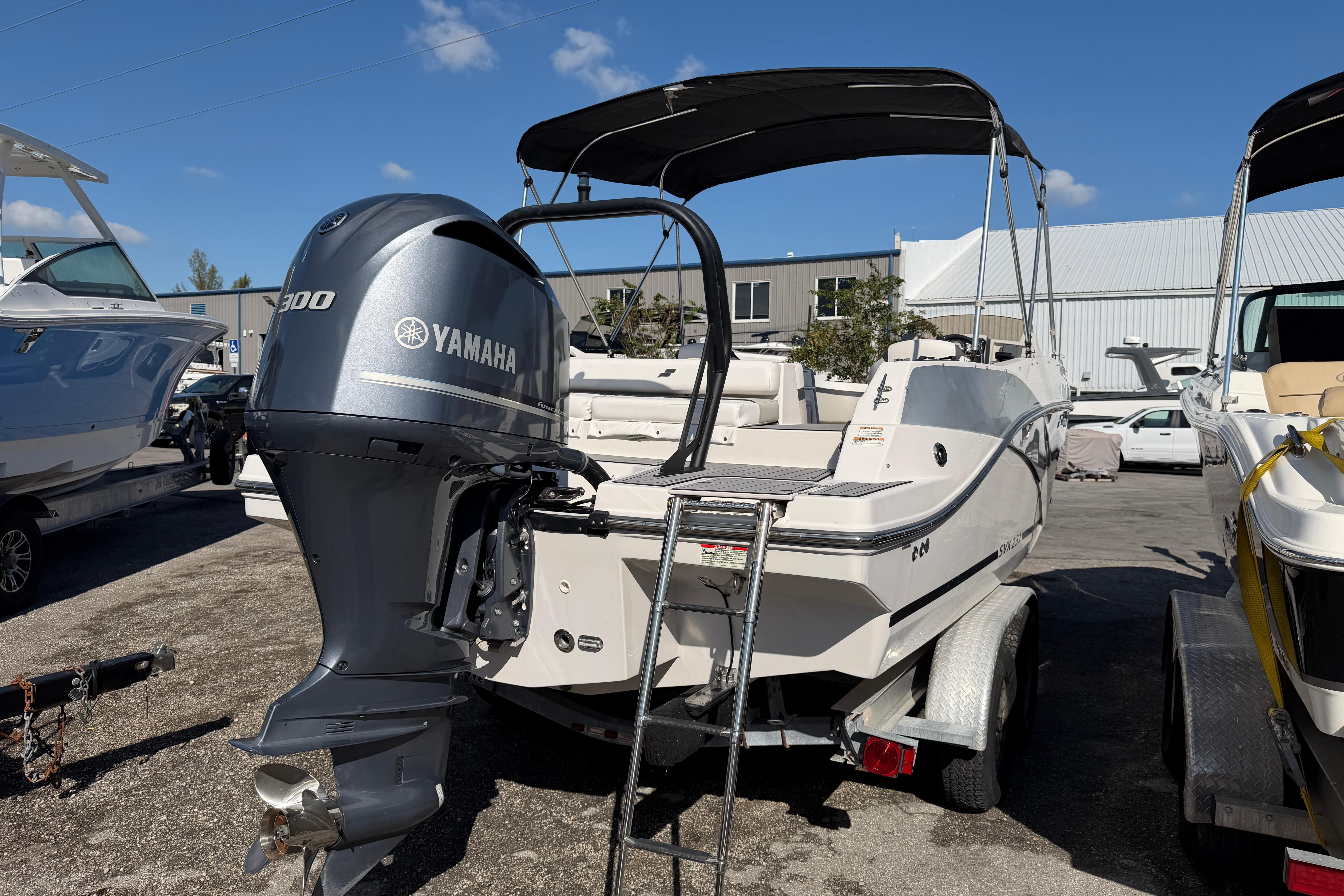 2023 Starcraft SVX 231 OB boat with Yamaha 300 engine, parked outdoors.