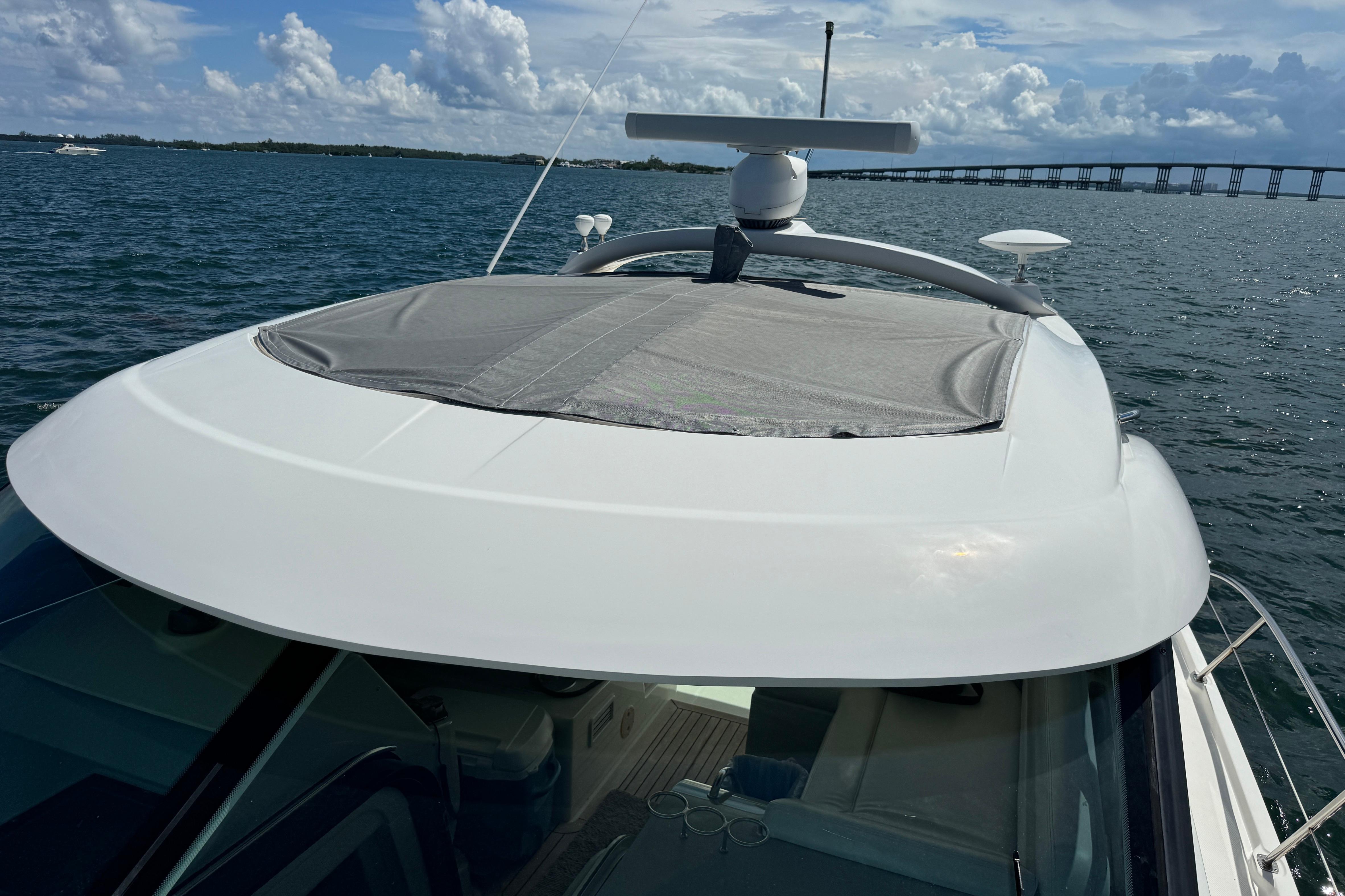 2011 Sea Ray 470 Sundancer yacht on water, bridge in background, sunny day.