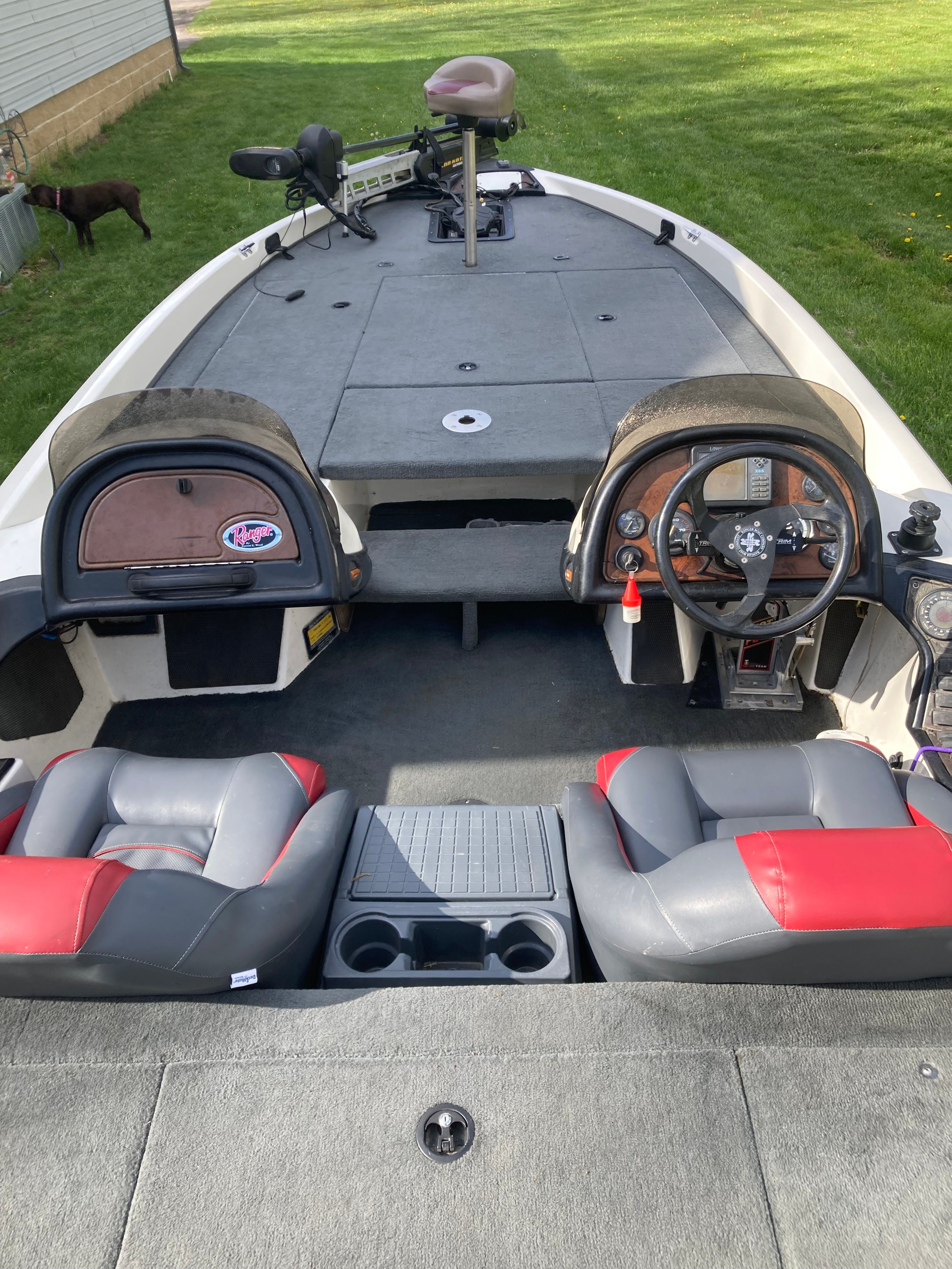 The image shows the cockpit of a 2002 Ranger 522DVX Comanche boat with two seats and a helm.