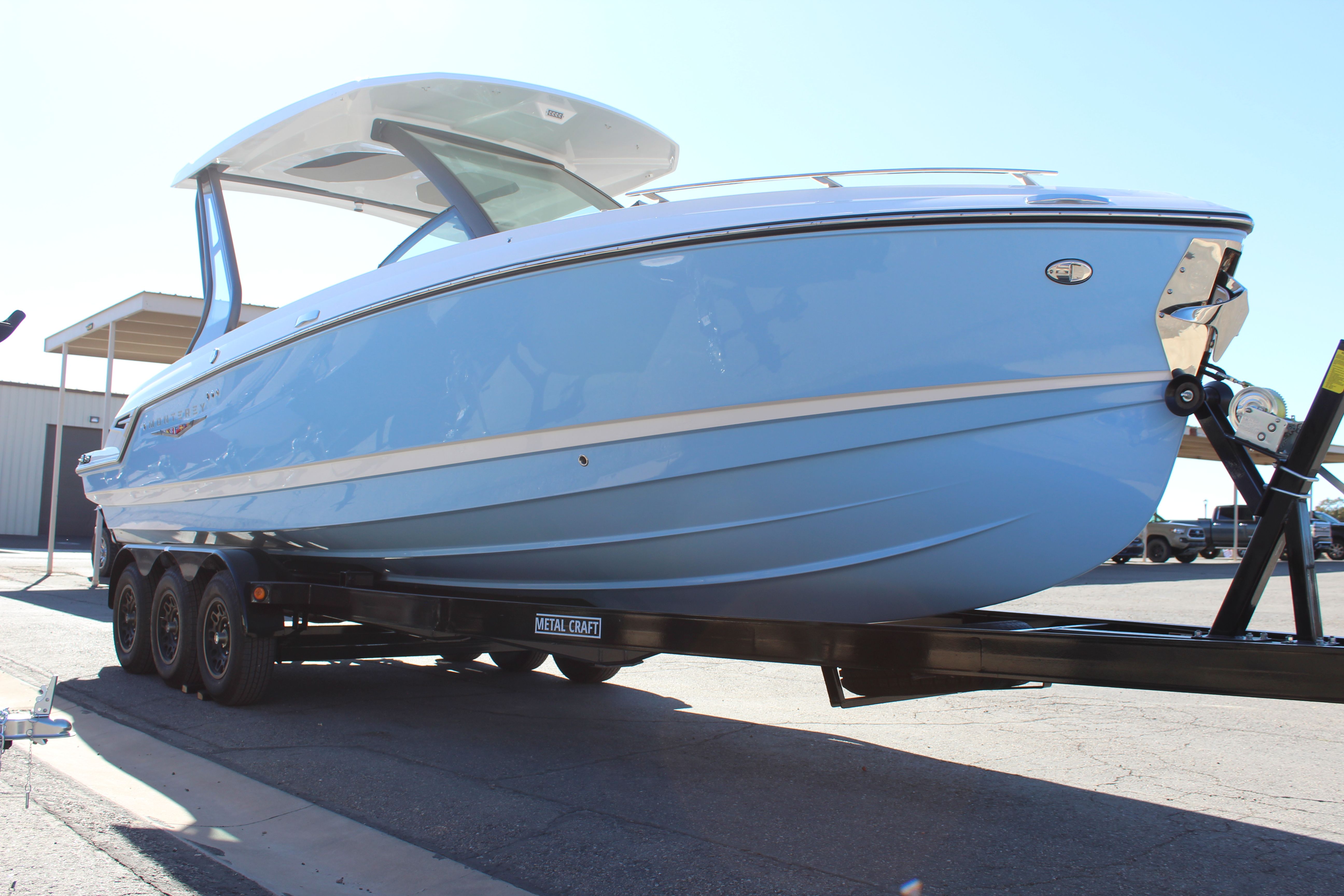 2025 Monterey Elite 27 OB boat on trailer, side view.