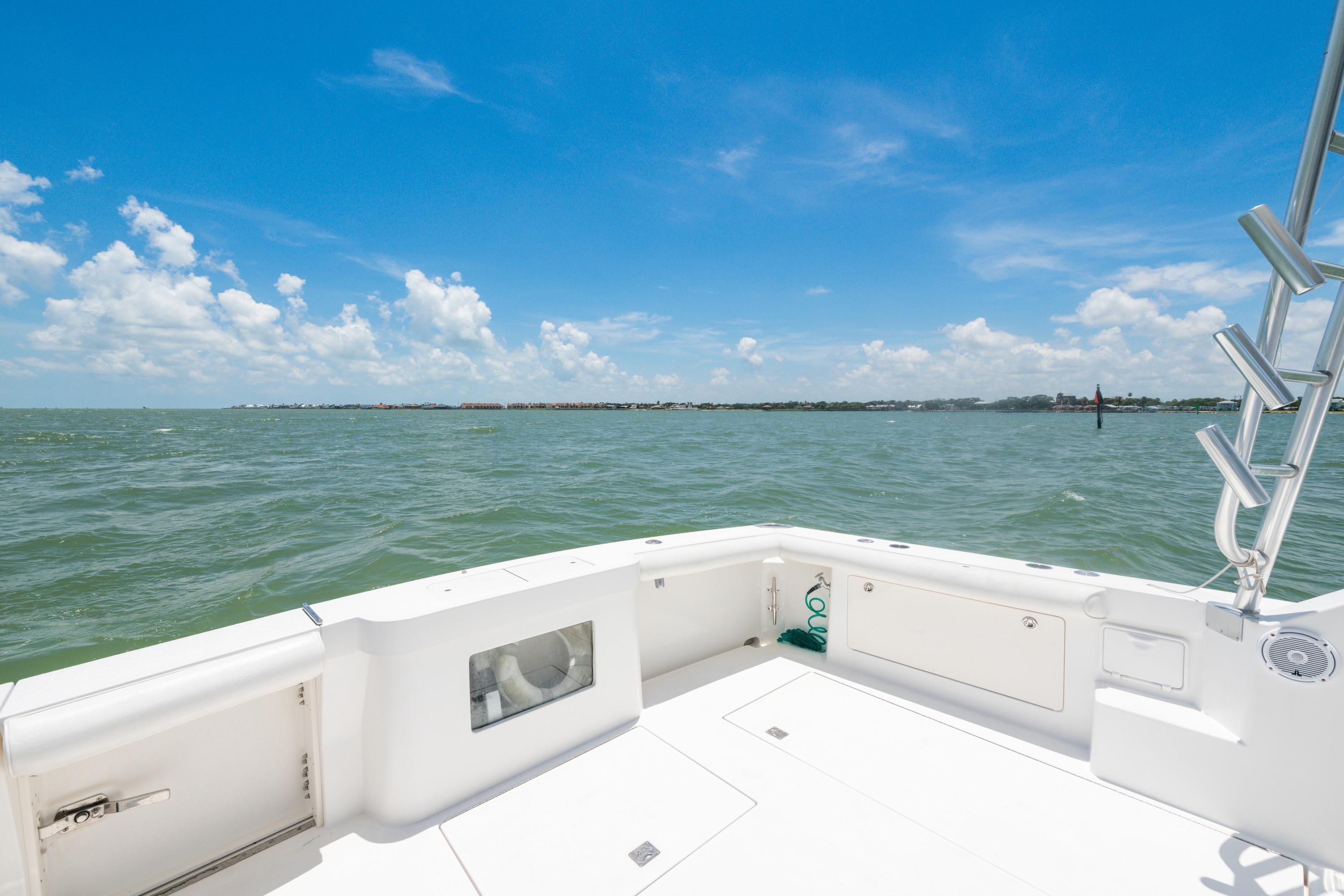 2010 Cabo 45 Express boat deck with ocean view under clear blue sky.