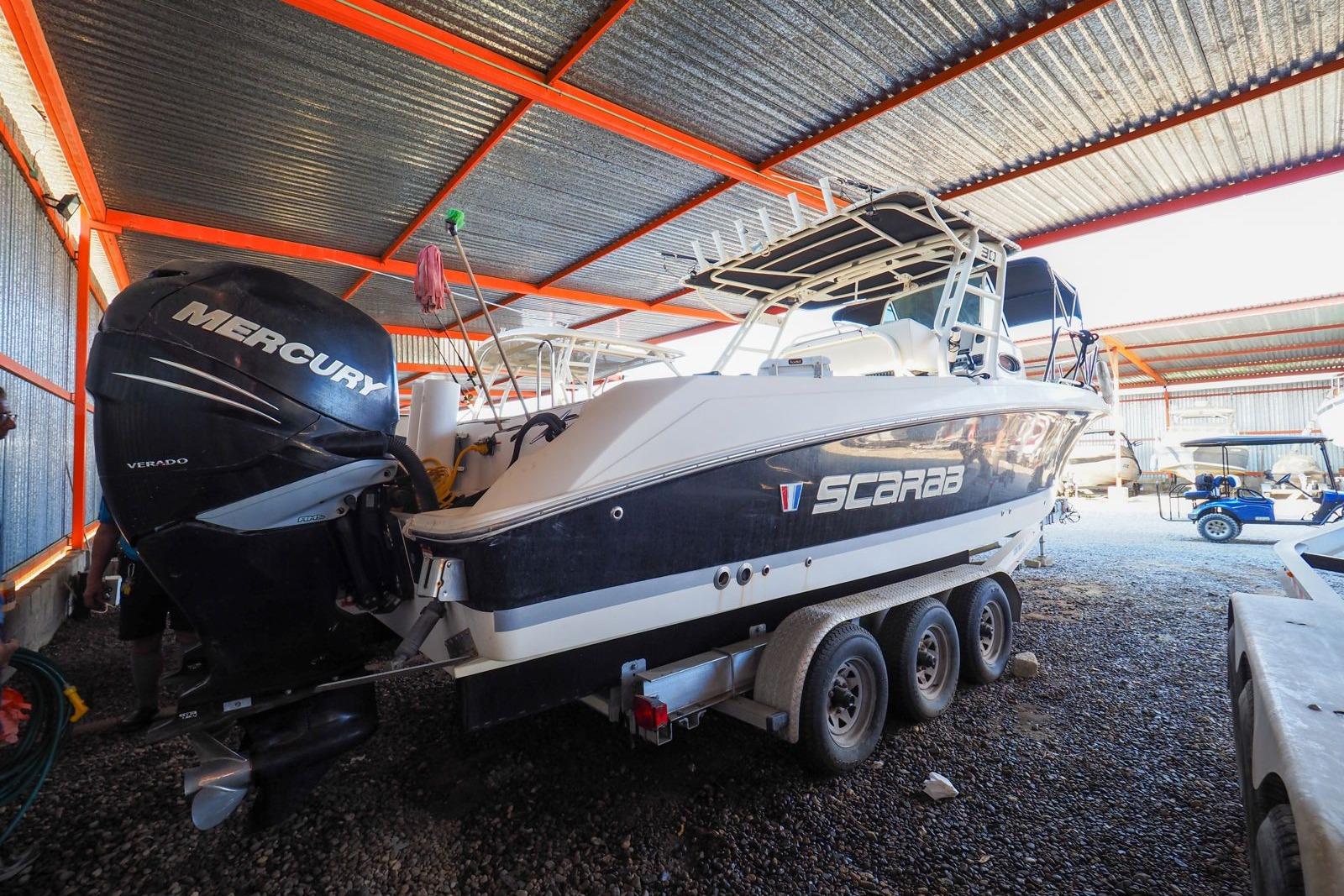 2011 Wellcraft 30 Scarab Sport boat with Mercury engine in covered storage.