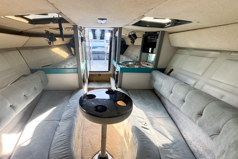 Interior of a 1989 Formula 292 SR-1 boat with plush seating and compact kitchenette.