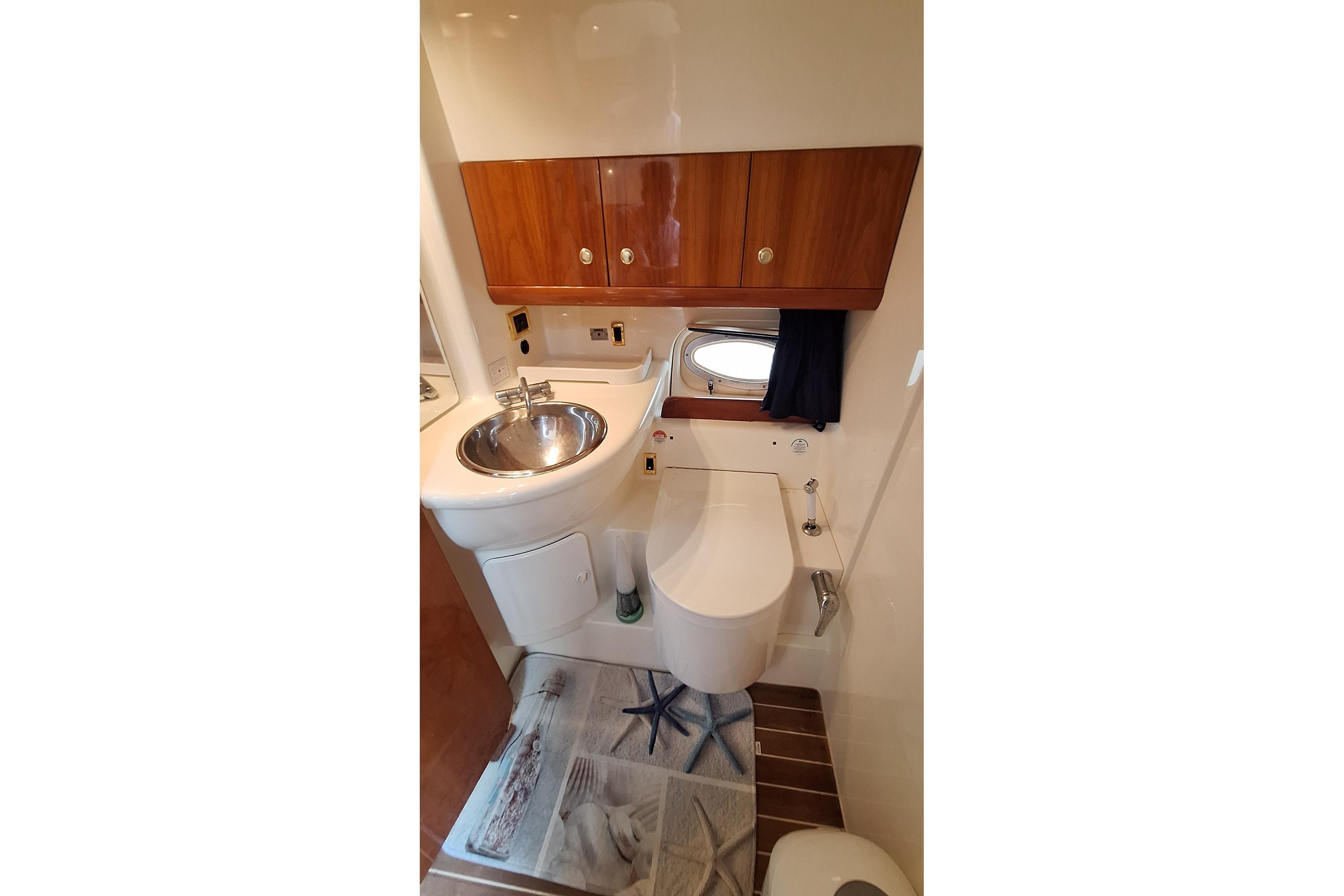 Bathroom interior of 2005 Cranchi Smeraldo 37 yacht with sink and wooden cabinets.