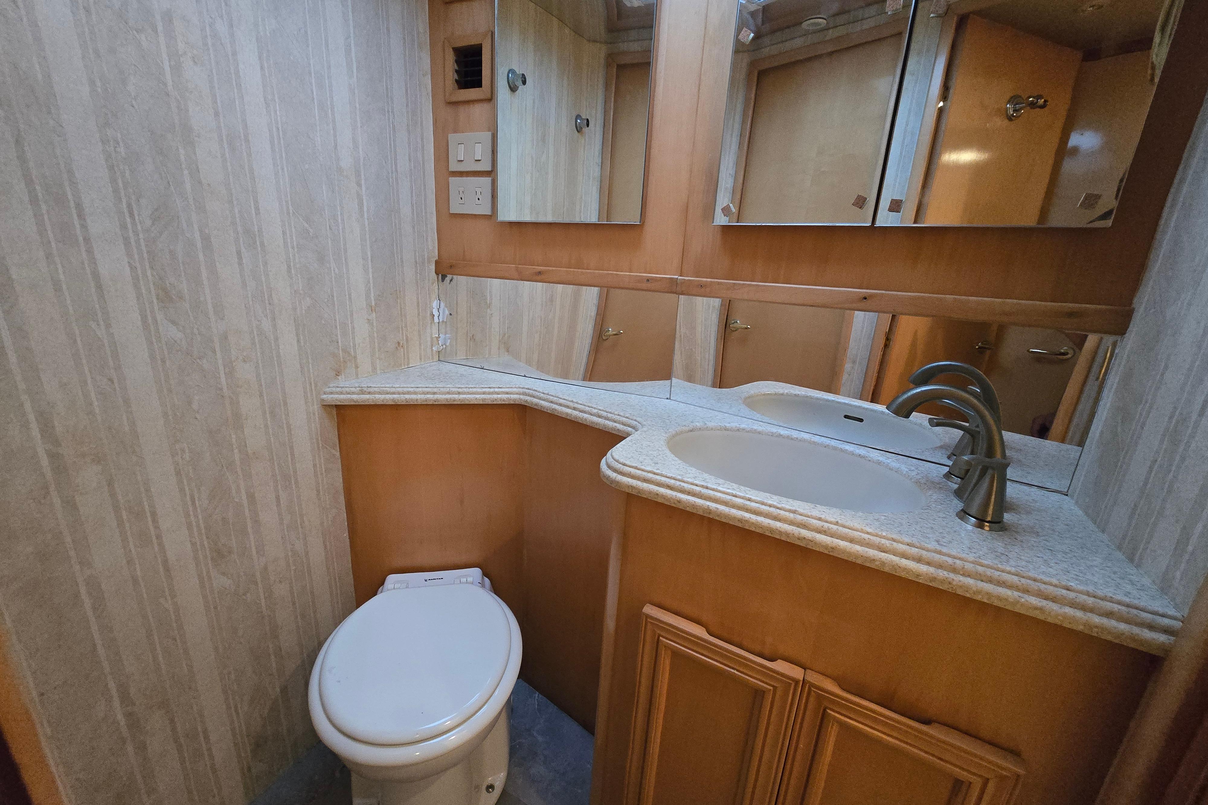 Bathroom interior of 2001 Cavileer 53 Convertible yacht with dual sinks and wooden cabinetry.