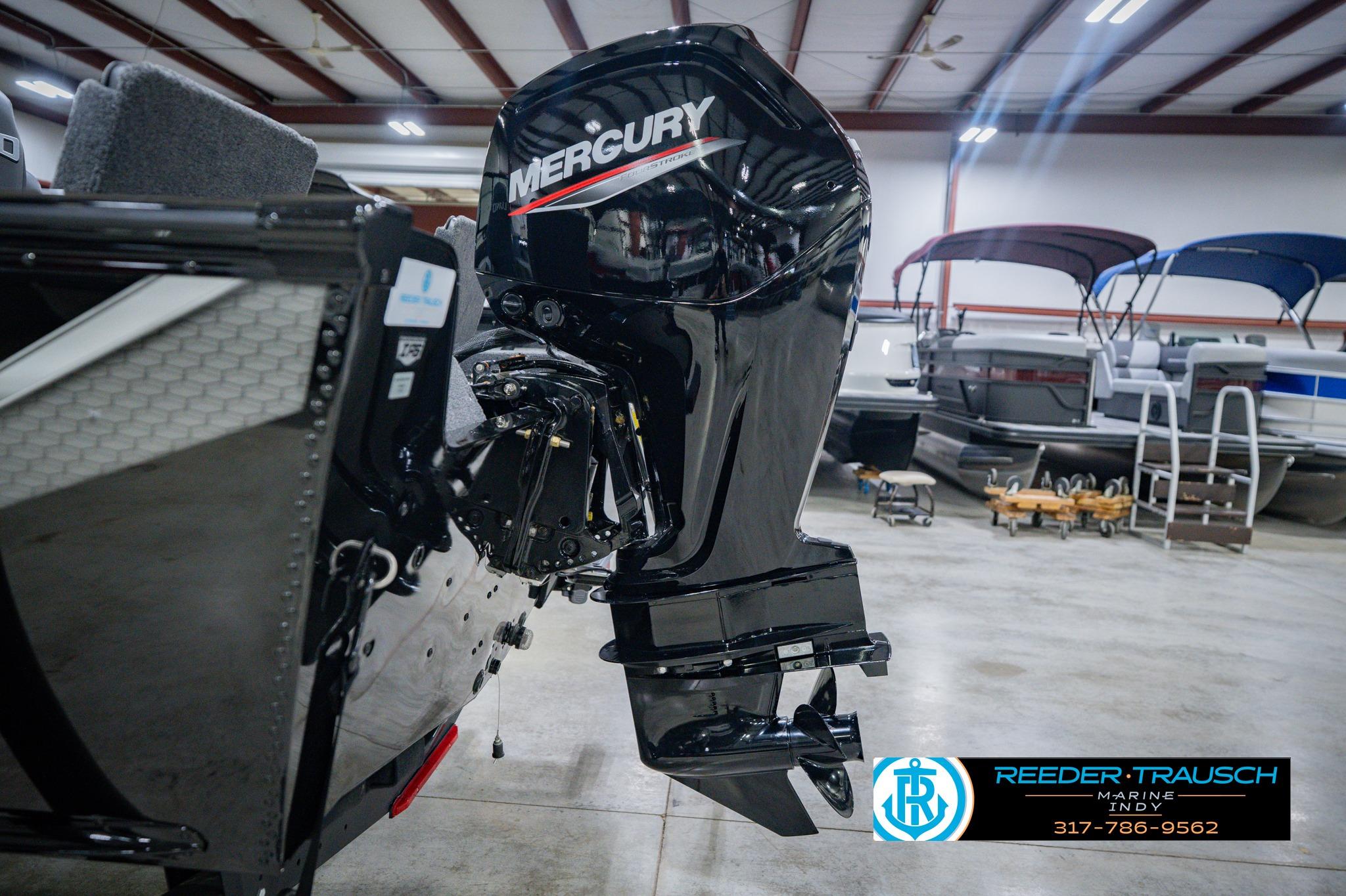 2026 Lund 1775 Impact XS boat with Mercury outboard motor in showroom.