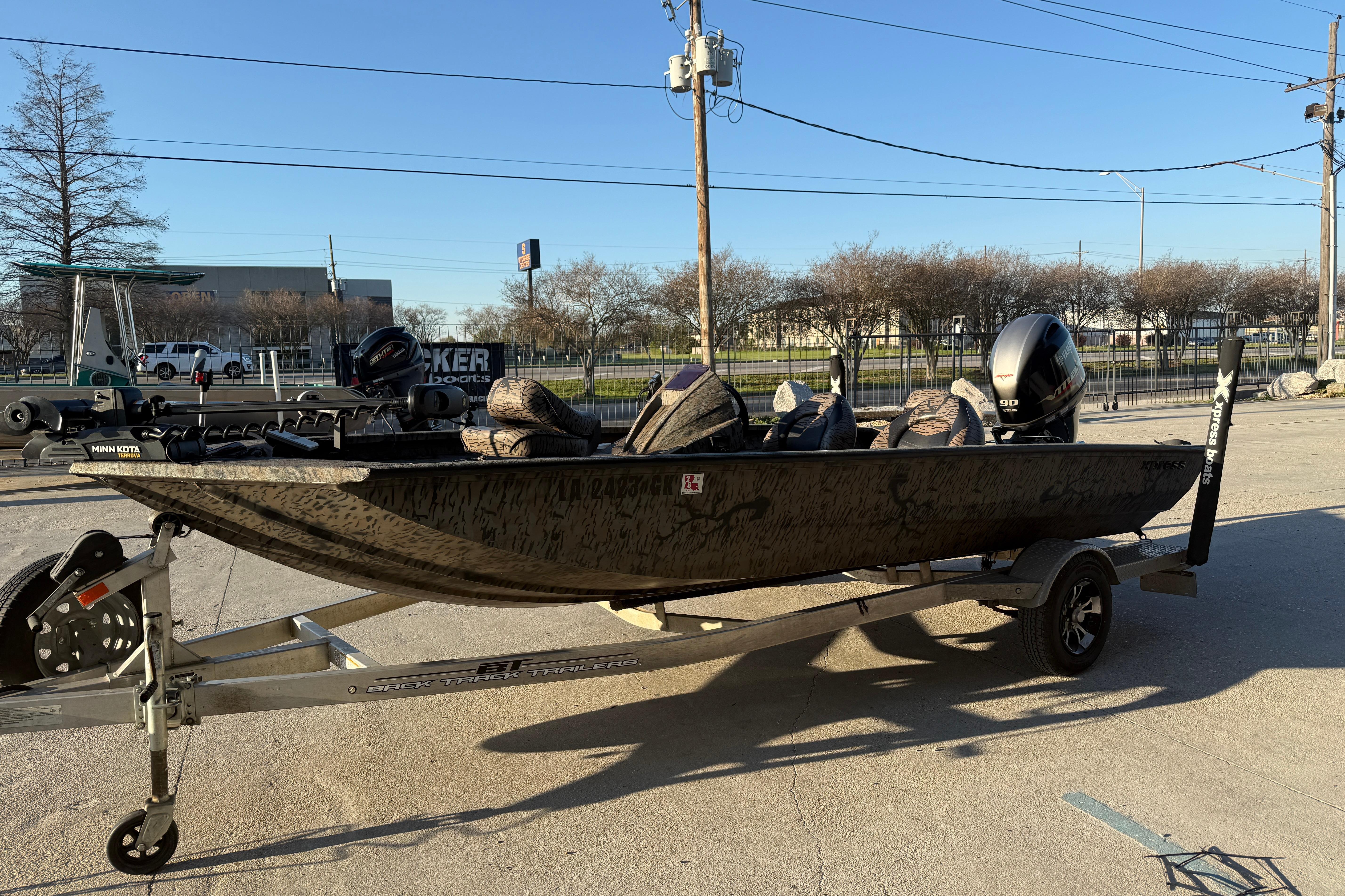 2019 Xpress XP7 boat on trailer, parked outdoors, with motor and accessories.