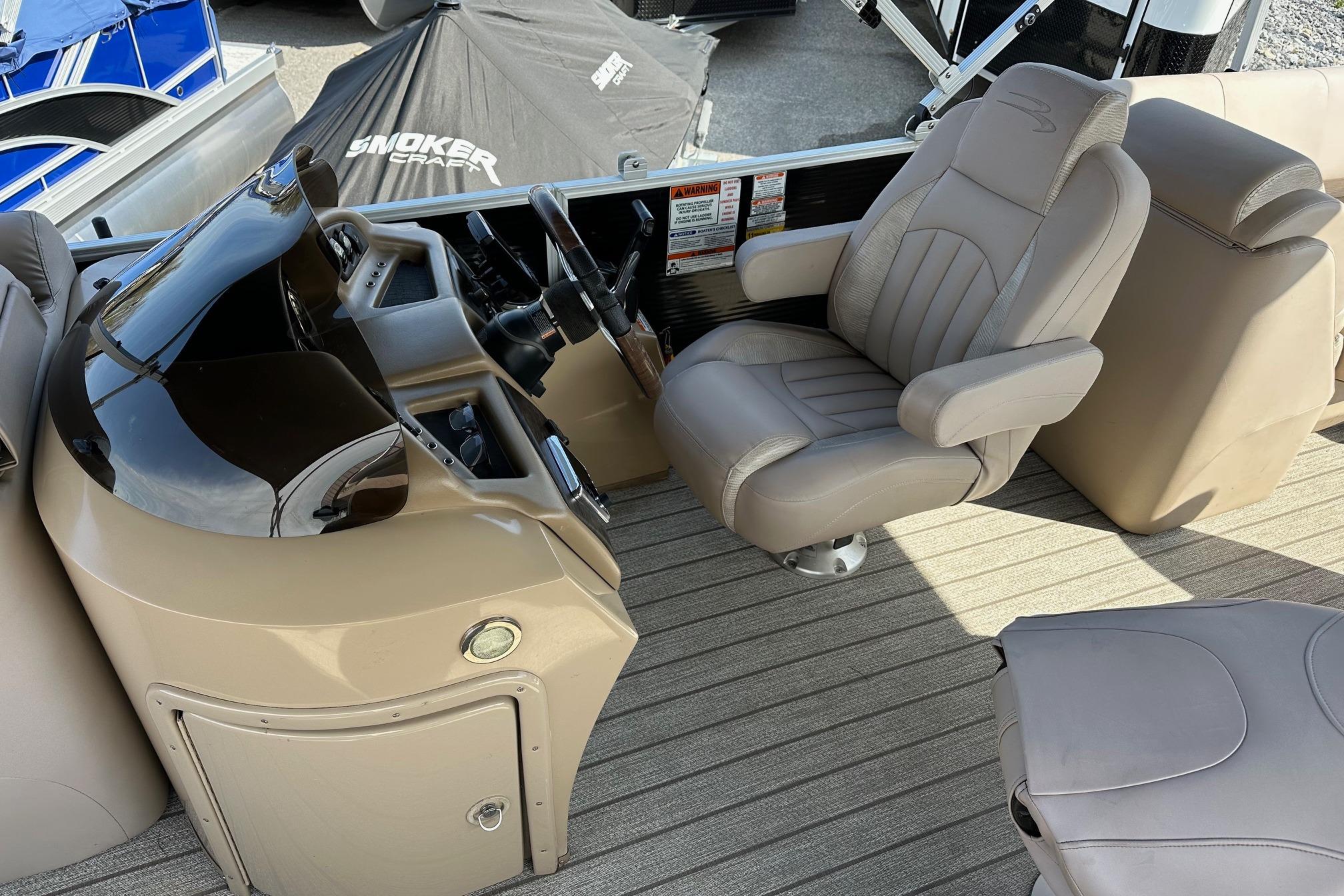 Captain's seat and helm of a 2017 Bennington 22 GPD pontoon boat.