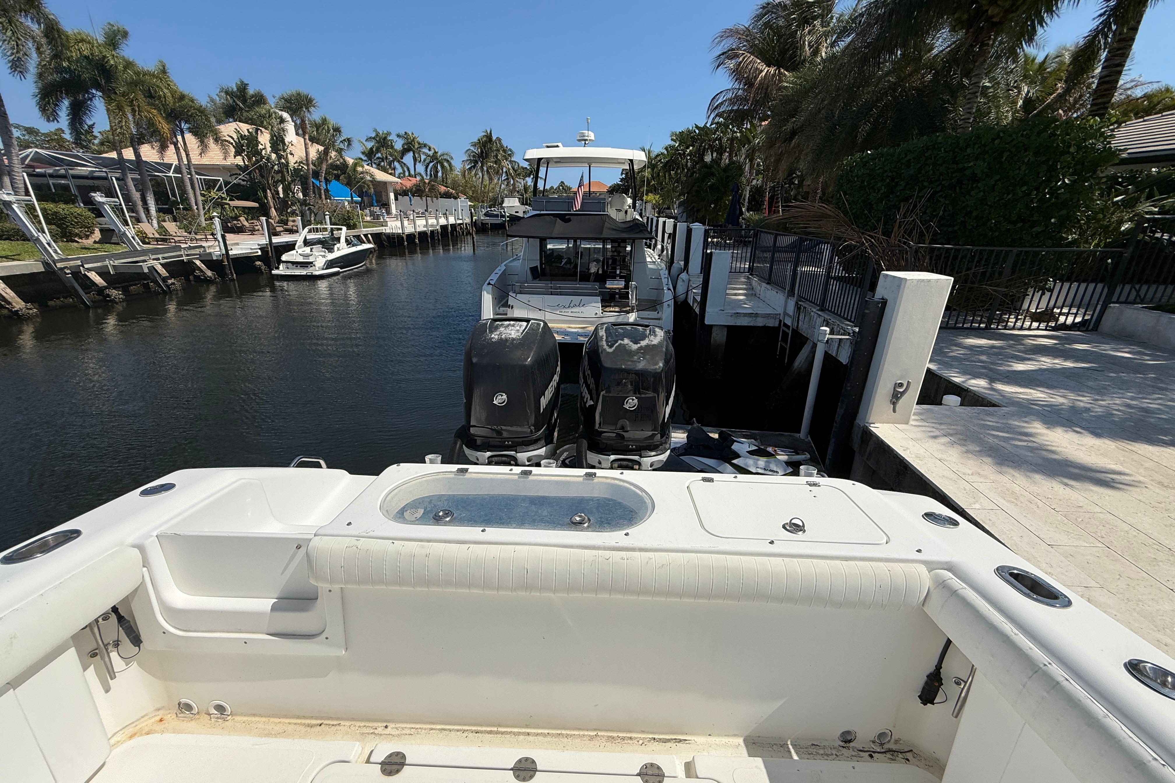 2003 Palmetto 33 Adventure boat docked in a sunny canal with palm trees.