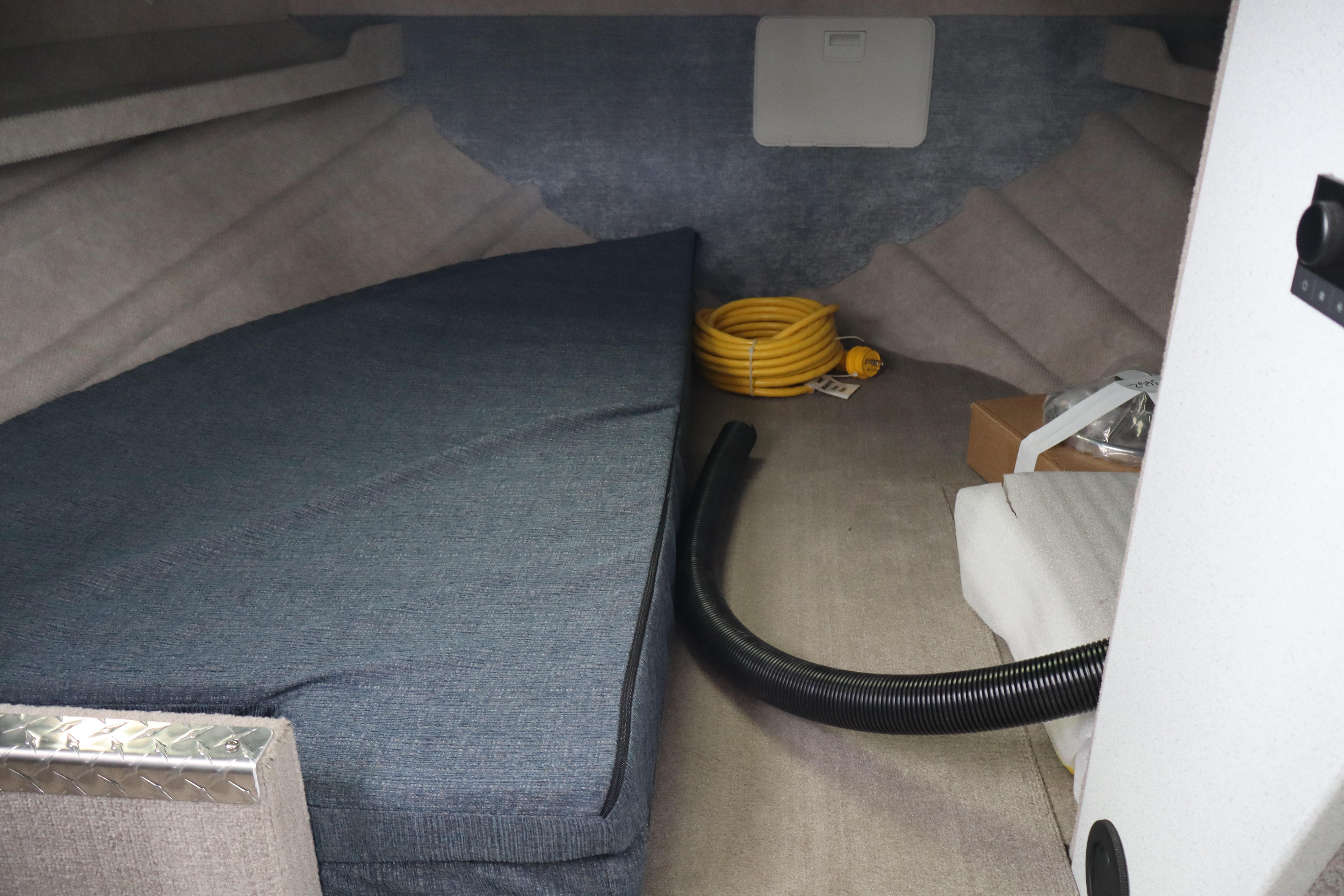 Interior cabin of 2026 KingFisher 3025 XRS boat with mattress and coiled hose.