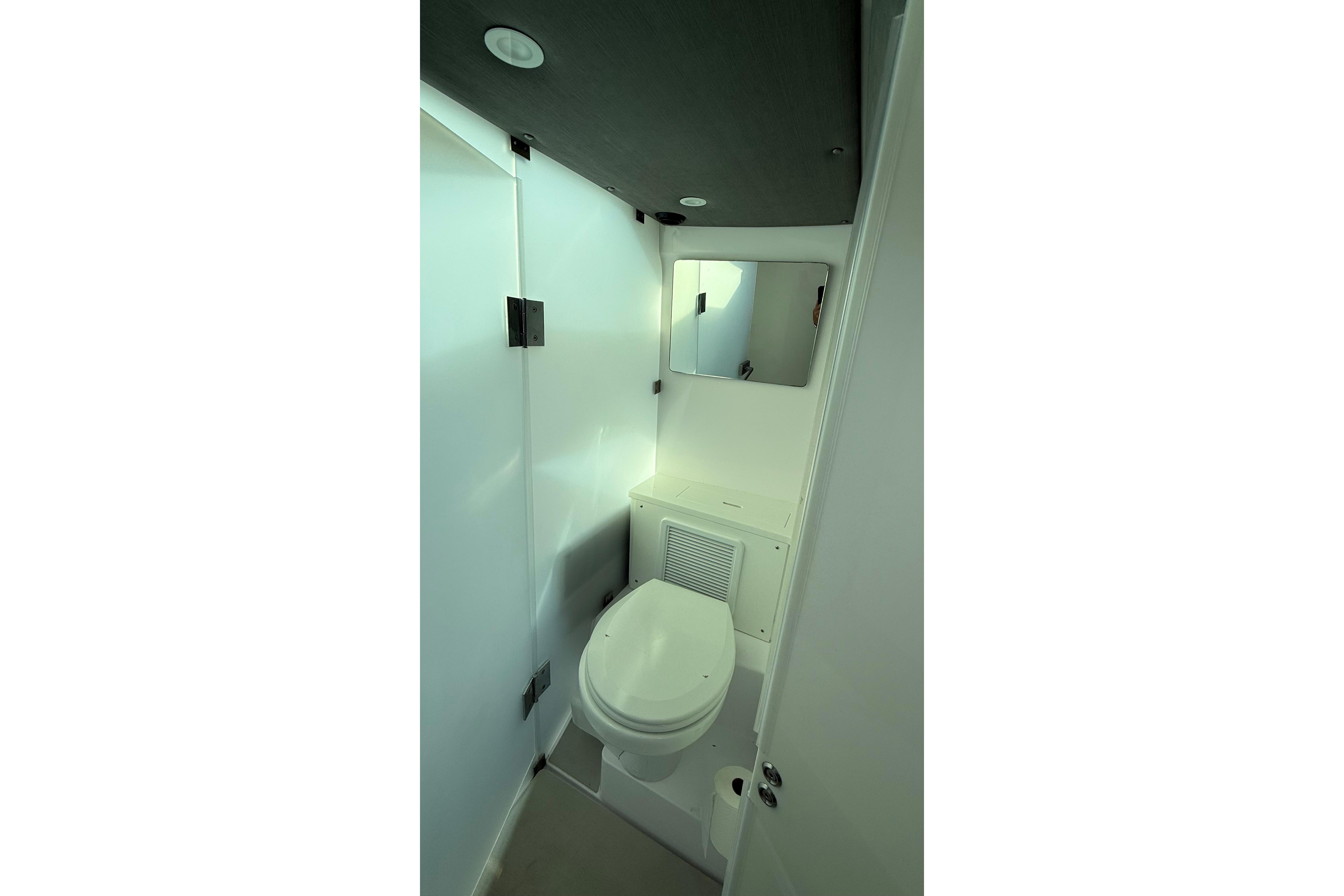 Compact bathroom in 2023 Axopar 37 XC CROSS CABIN with toilet and mirror.