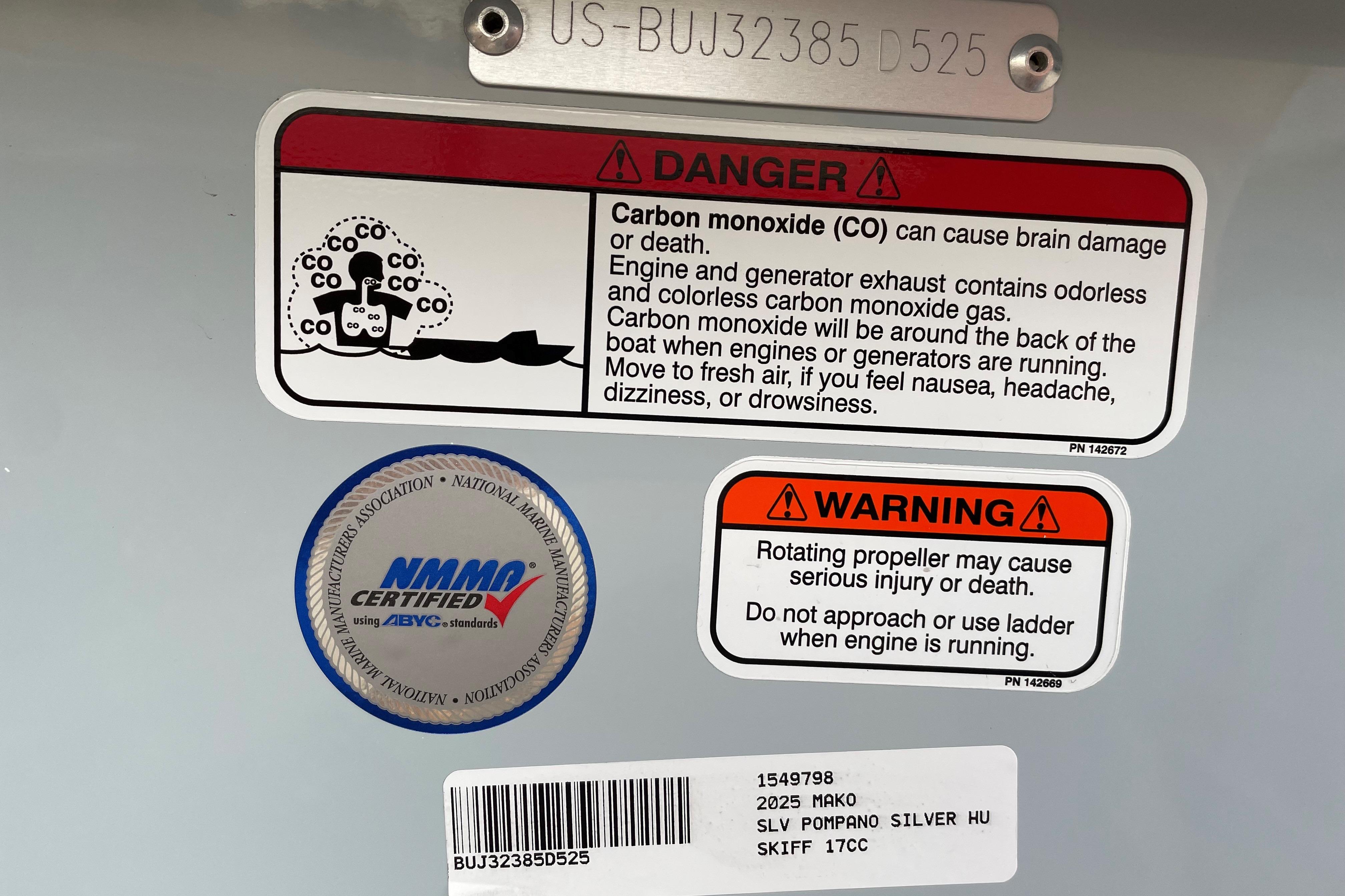 2025 Mako Pro Skiff 17 CC warning labels for carbon monoxide and propeller safety.