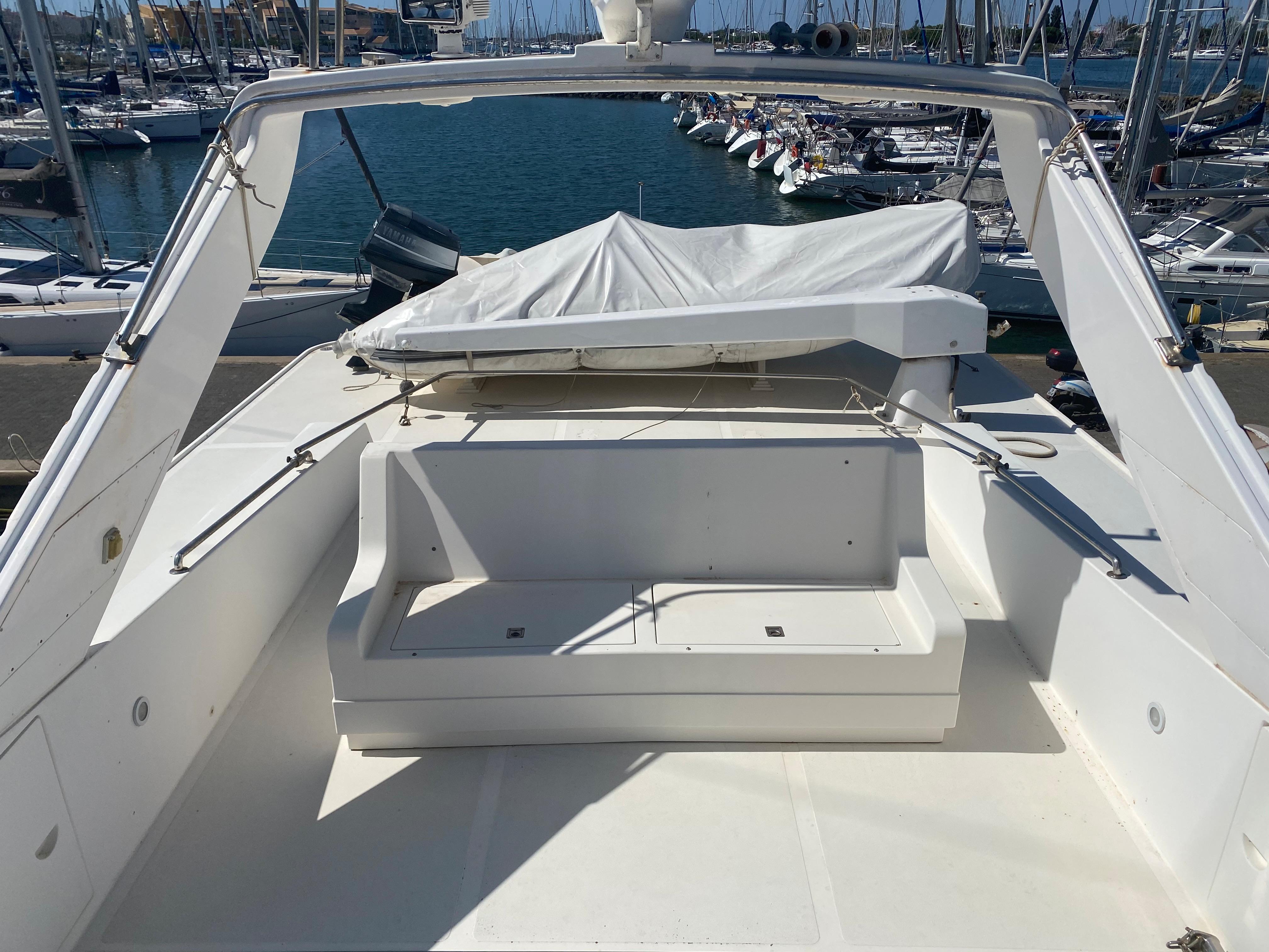 1994 Falcon 76 yacht in harbor, white seating area.