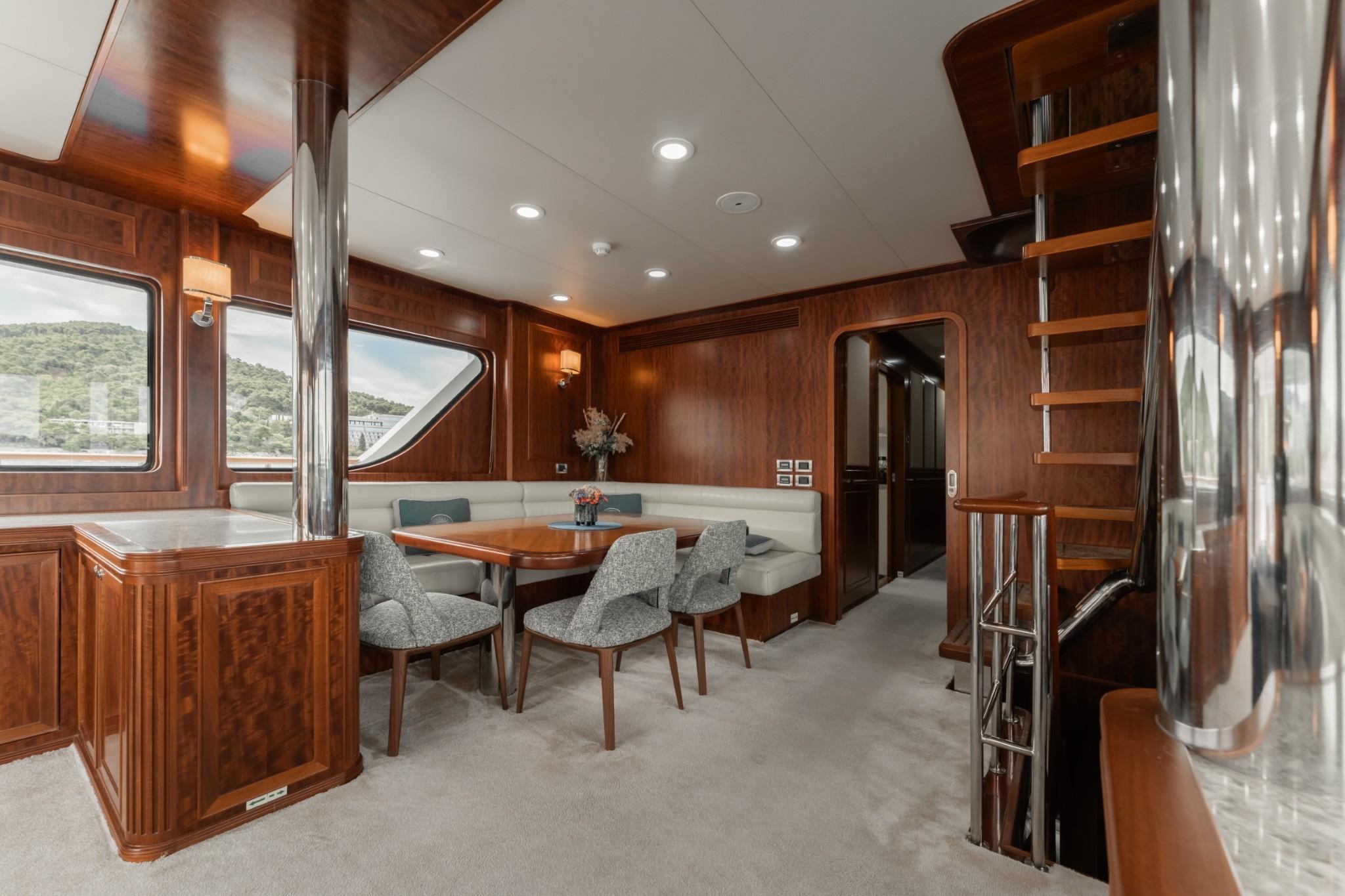 Luxurious interior of 2017 Bering 80 yacht with elegant dining area and wooden finishes.