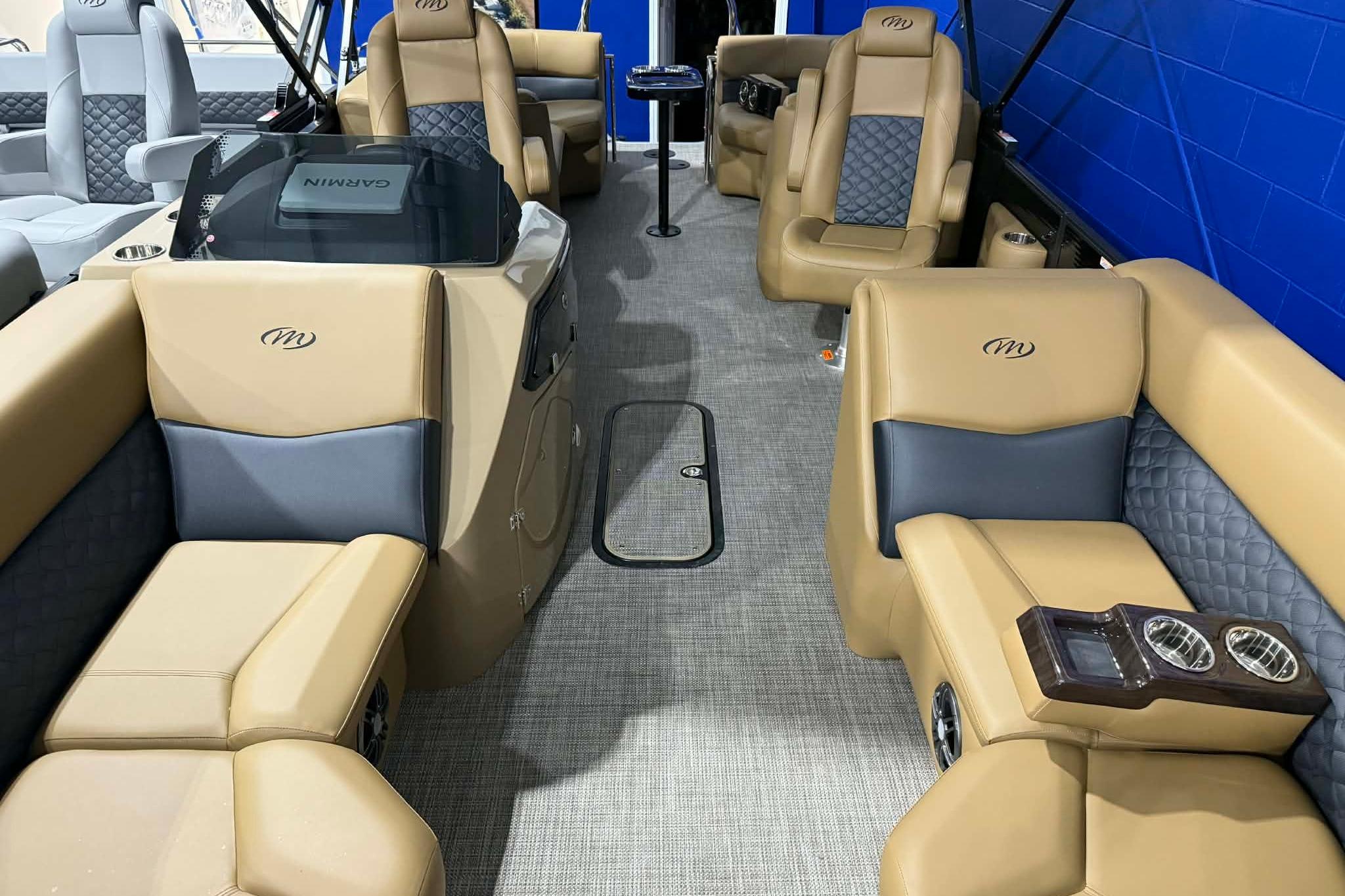 Luxurious interior of 2026 Manitou Encore VP 230 pontoon boat with tan and gray seating.