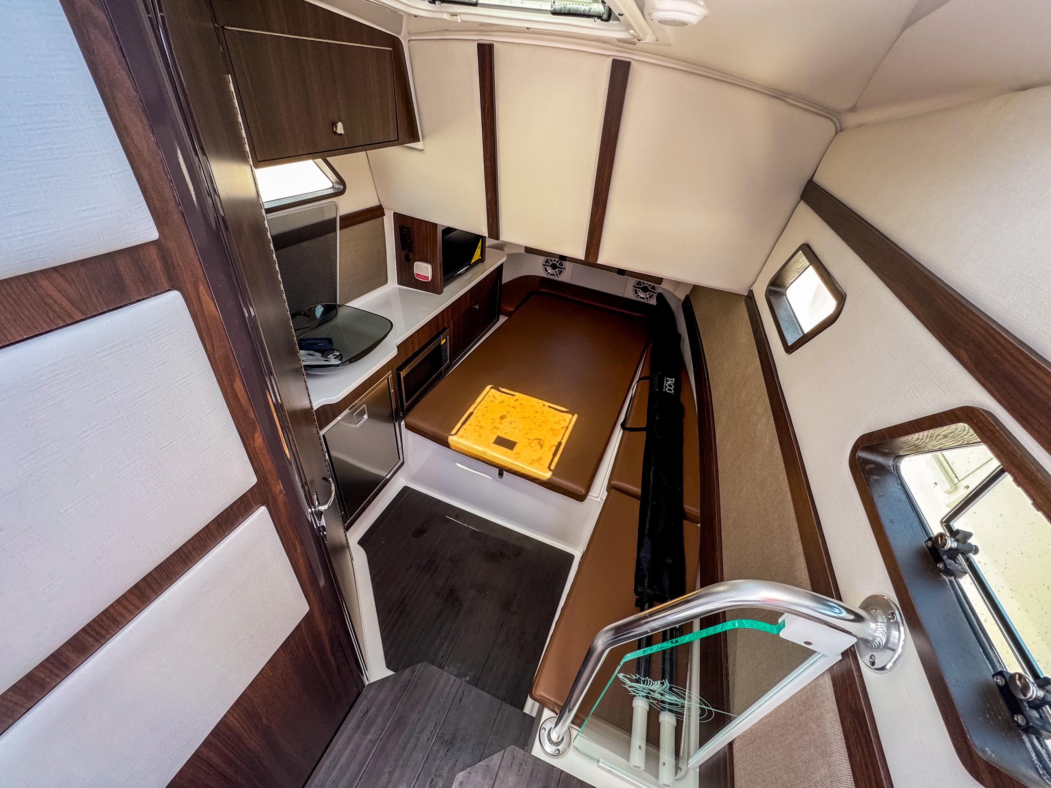 Interior of 2025 Edgewater 370CC boat, featuring modern kitchen and cozy seating area.
