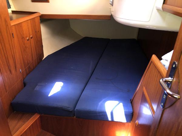 Cozy cabin interior of 2001 Jeanneau 45.2 sailboat with blue mattress.