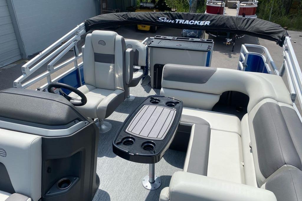 2026 Sun Tracker Fishin' Barge 20 DLX interior with seating and table setup.