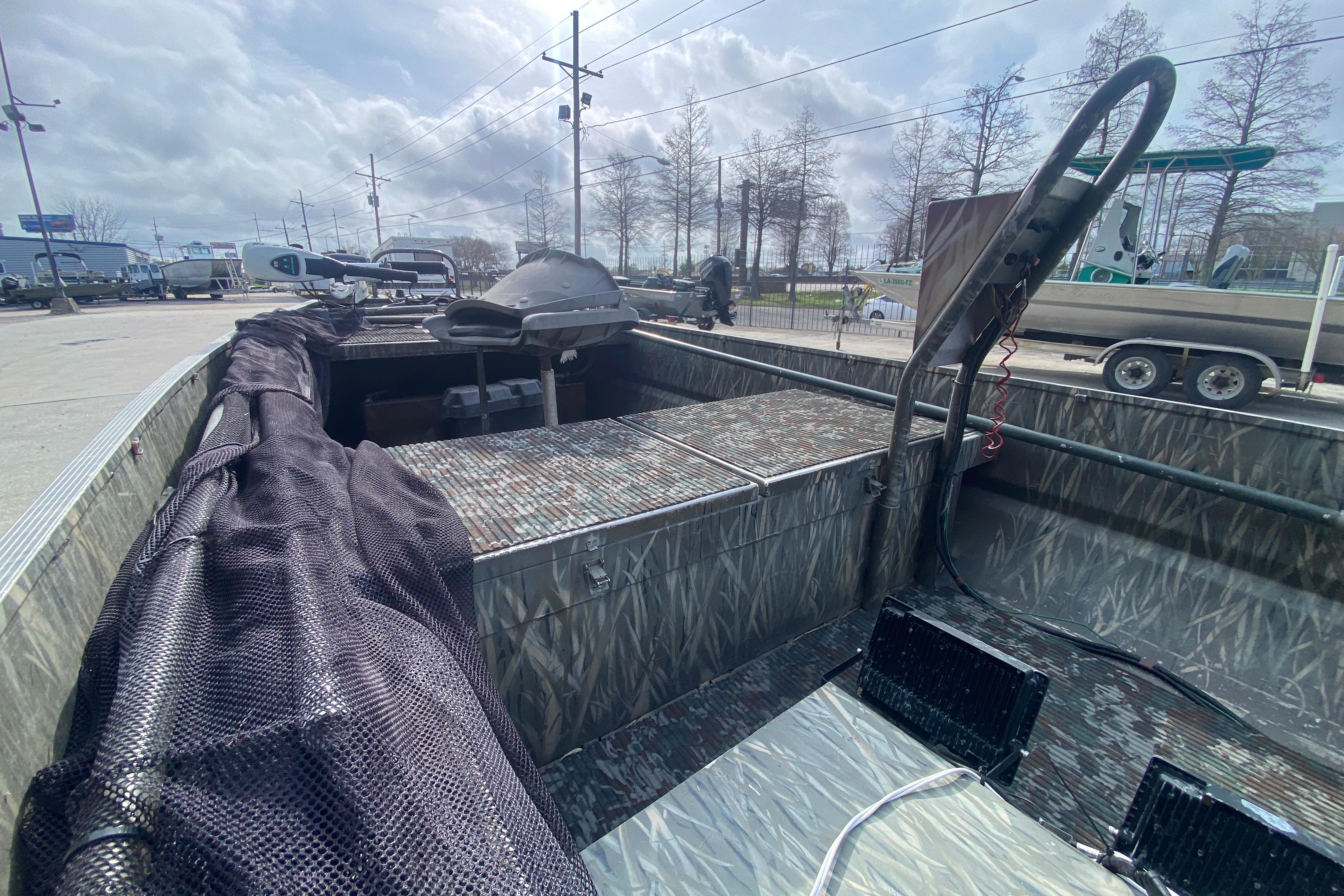 2009 Gator Trax MUD BUDDY 17 X 50 boat with camouflage interior, parked outdoors.